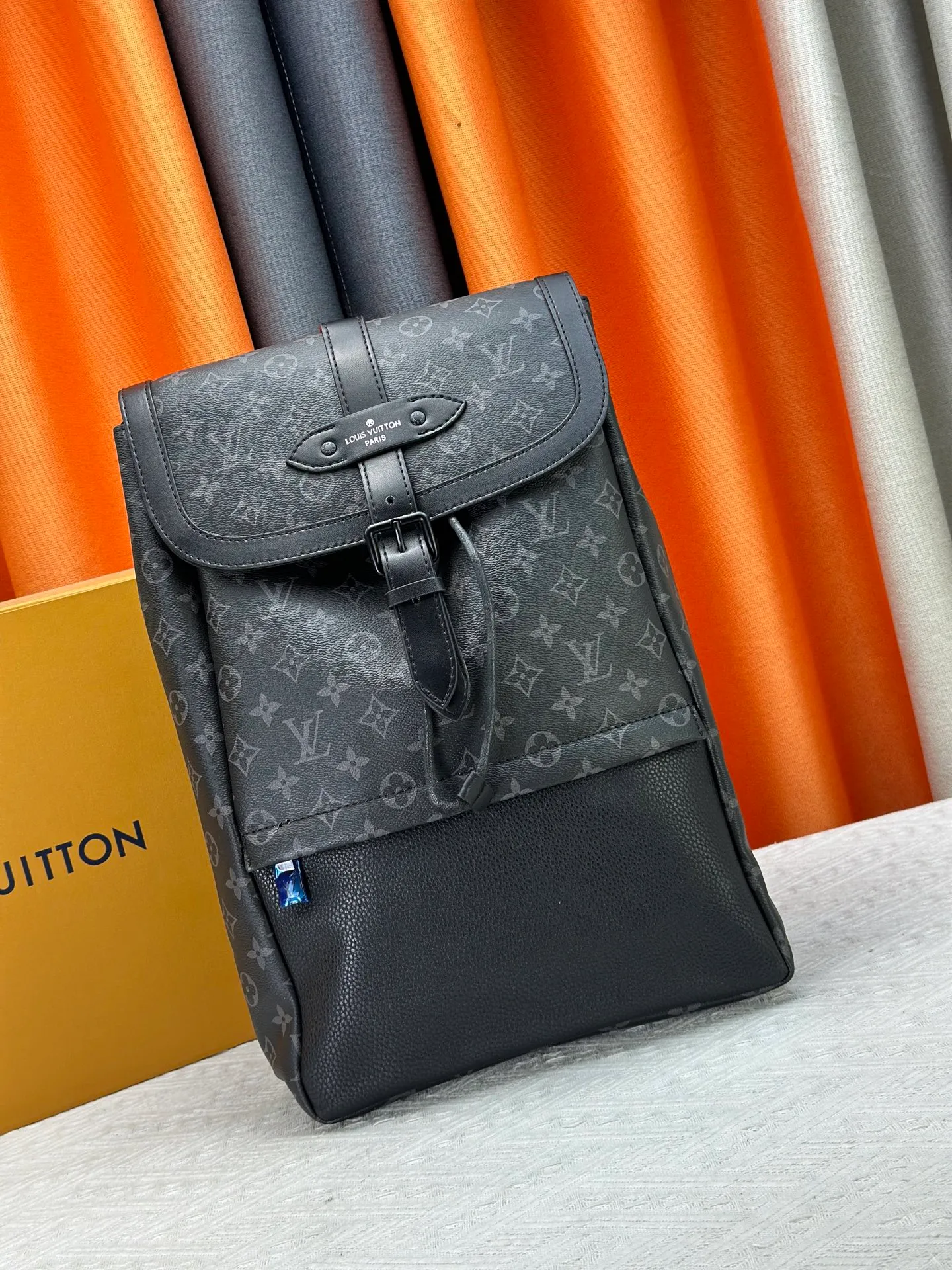 P360 M45913 The new Saumur backpack gives a modern touch to Louis Vuitton’s classic piece, the equestrian-style Saumur handbag born in 1986. The understated Monogram Eclipse canvas is paired with leather details inspired by the brand's heritage, including buckled shoulder straps with hidden magnetic closures. Equipped with a spacious main compartment and a unique notebook pocket, it is versatile and a perfect companion for daily travel. Dimensions: 27.0 x 42.0 x 13.0 cm (length x height x width)-7