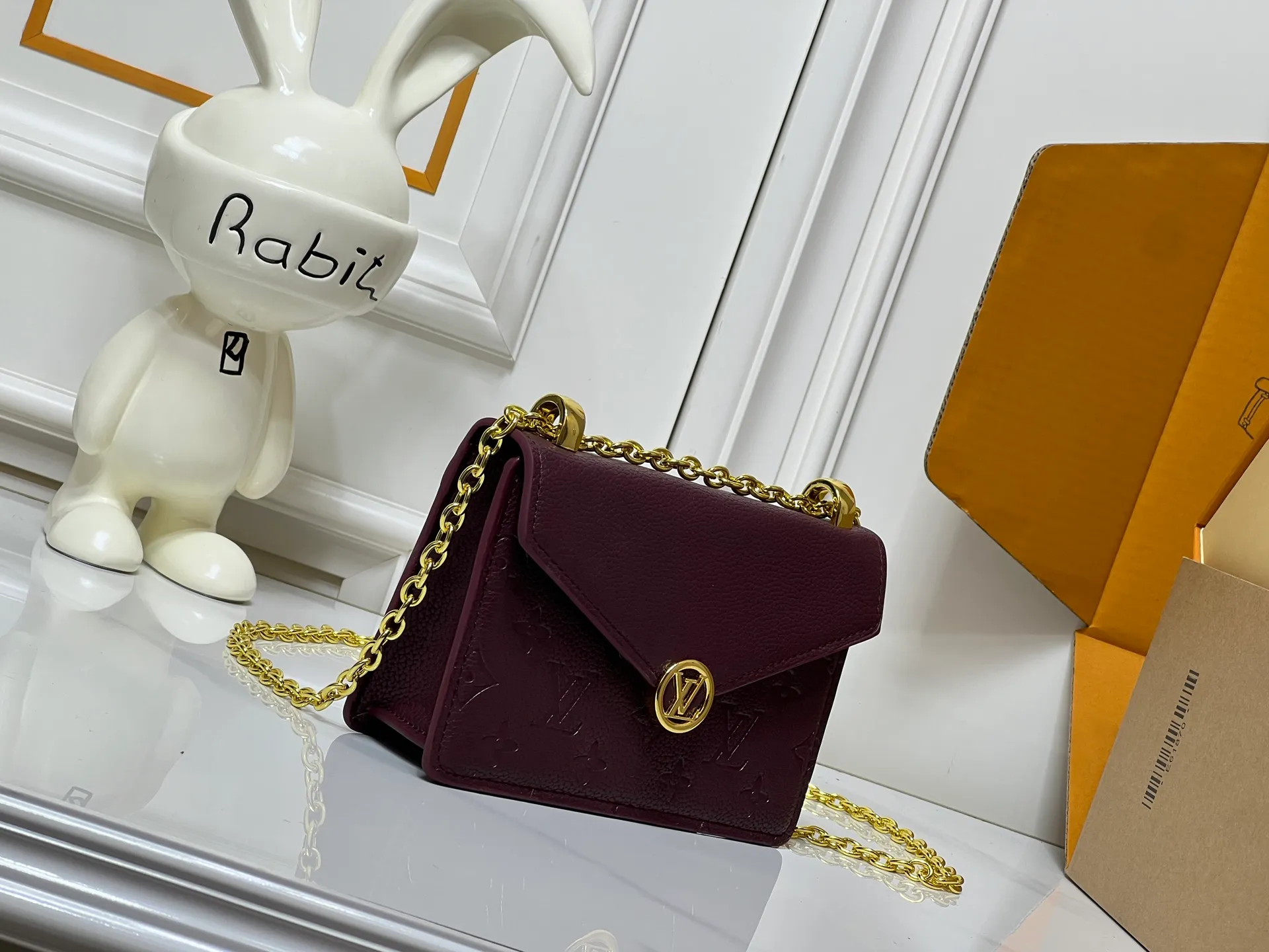 Batch 220💰M13569 black M13570 gray M25814 burgundy (chain/embossed) [Portefeuille chaîne Rosy] This Rosy chain wallet is both fashionable and practical, adding a modern spirit to the Monogram Empreinte series. It has an elegant LV circle and a V-shaped flap, two hallmarks of the house. The magnetic closure reveals a surprise Monogram flower, as well as three card slots and a flat interior pocket. The sliding chain allows you to wear it crosswise or over the shoulder.  Dimensions: 19.5 x 13.5 x 6.5 cm