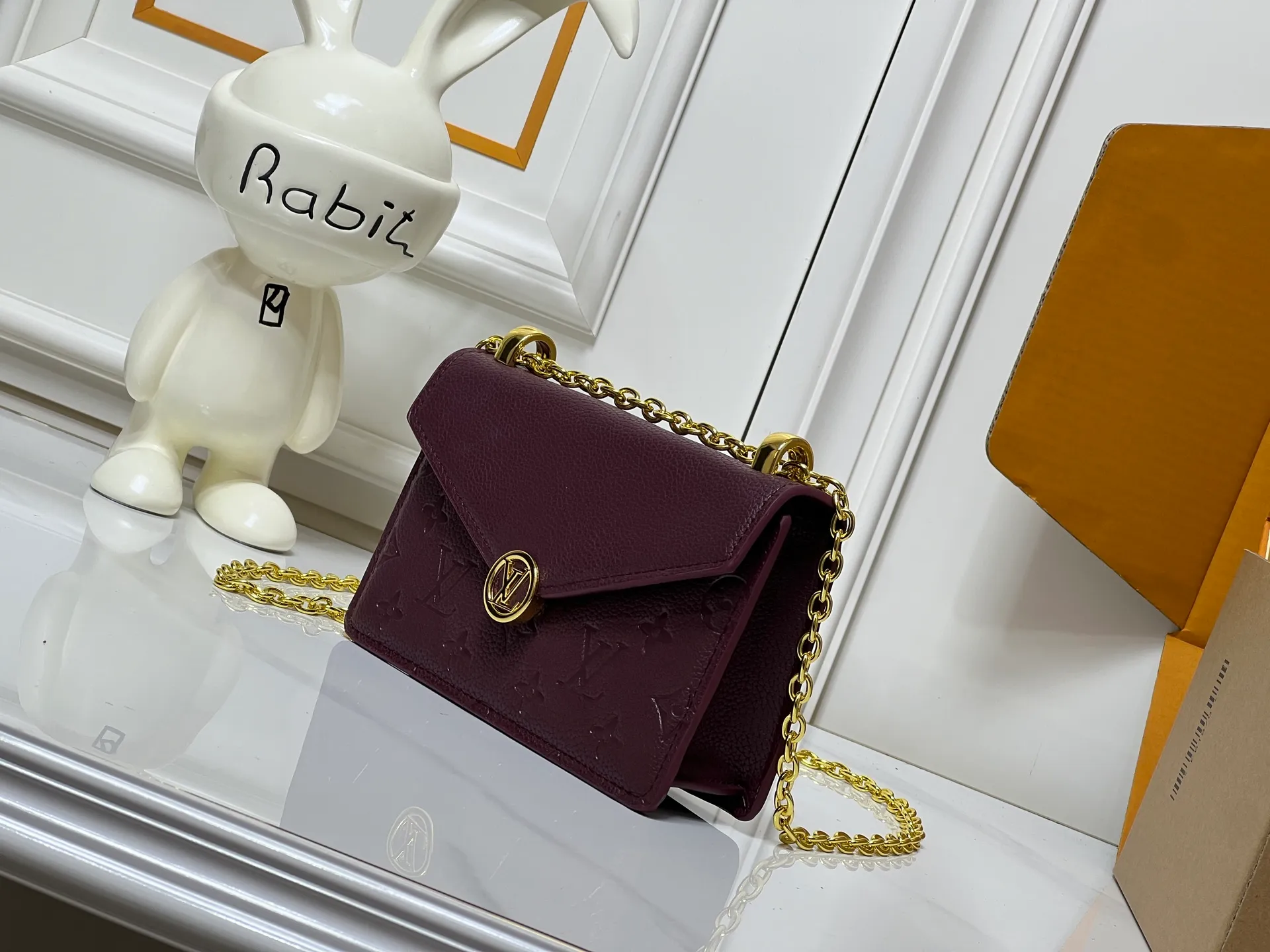 Batch 220💰M13569 black M13570 gray M25814 burgundy (chain/embossed) [Portefeuille chaîne Rosy] This Rosy chain wallet is both fashionable and practical, adding a modern spirit to the Monogram Empreinte series. It has an elegant LV circle and a V-shaped flap, two hallmarks of the house. The magnetic closure reveals a surprise Monogram flower, as well as three card slots and a flat interior pocket. The sliding chain allows you to wear it crosswise or over the shoulder.  Dimensions: 19.5 x 13.5 x 6.5 cm