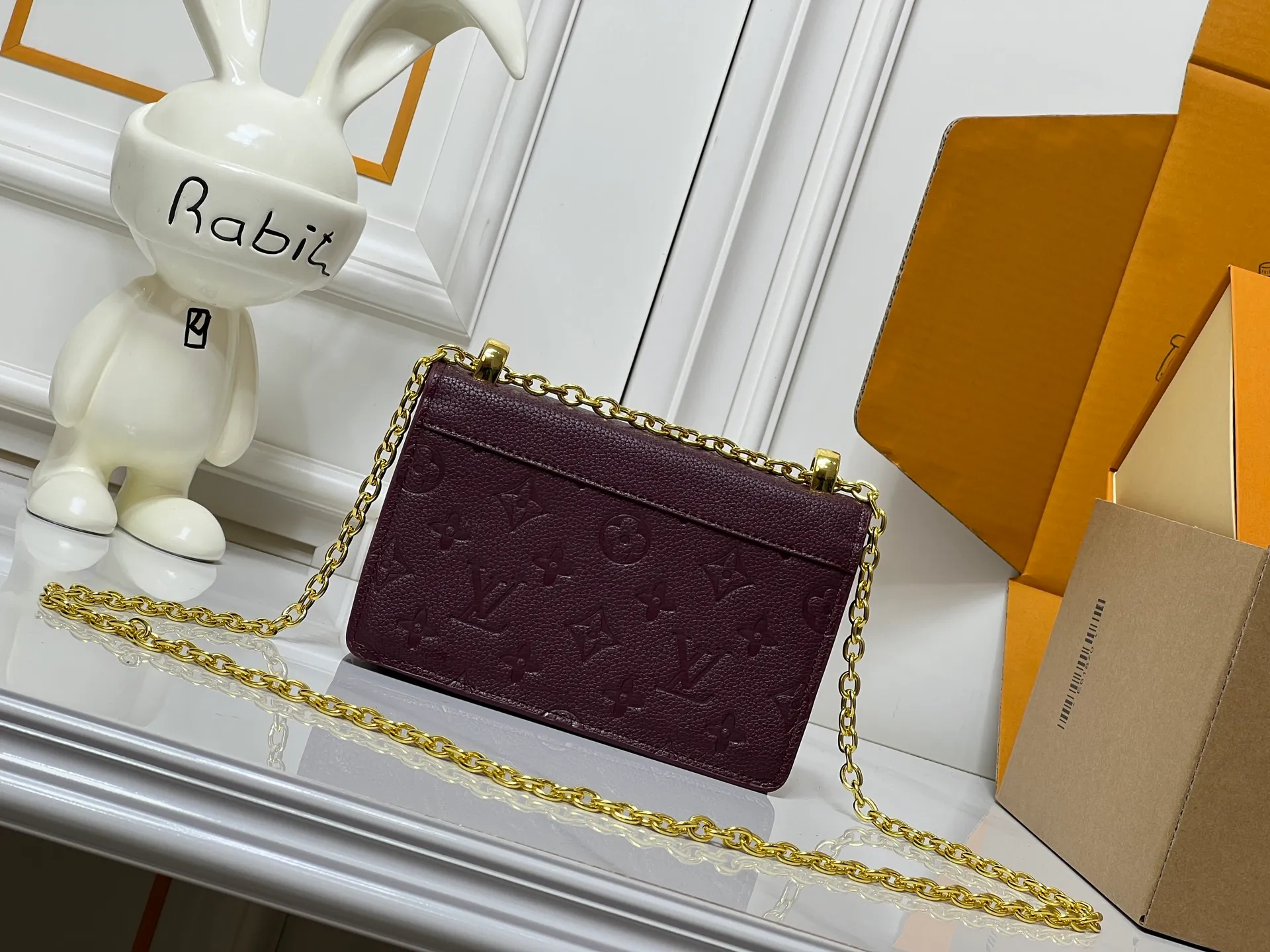Batch 220💰M13569 black M13570 gray M25814 burgundy (chain/embossed) [Portefeuille chaîne Rosy] This Rosy chain wallet is both fashionable and practical, adding a modern spirit to the Monogram Empreinte series. It has an elegant LV circle and a V-shaped flap, two hallmarks of the house. The magnetic closure reveals a surprise Monogram flower, as well as three card slots and a flat interior pocket. The sliding chain allows you to wear it crosswise or over the shoulder.  Dimensions: 19.5 x 13.5 x 6.5 cm