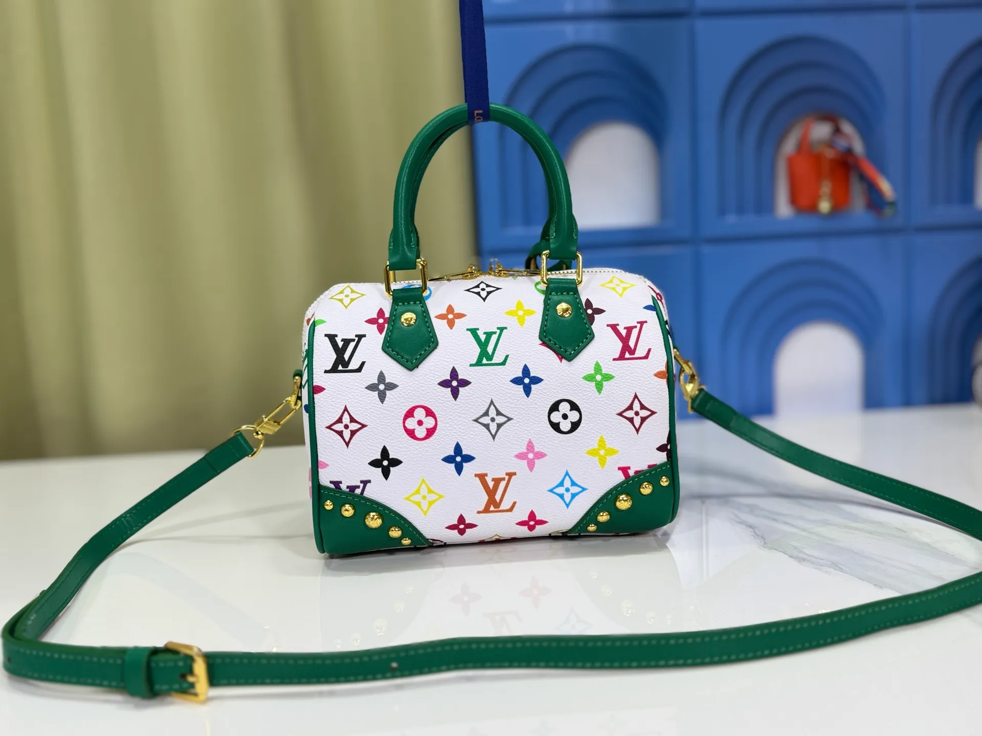 P280 upgraded original M58953 M46234 M46222 Speedy Bandoulière 20 handbag is made of soft coated canvas, and the full-length Monogram pattern is traced in colorful rainbow tones, highlighting the smart style of the Louis Vuitton x Murakami reissue series. The Toron handle and detachable shoulder strap are constructed of cow leather, the metal corners recall classic luggage elements, and the bow-shaped key bag and padlock add brand touches. Dimensions: 20.5 x 13.5 x 12.0 cm (length x height x width)