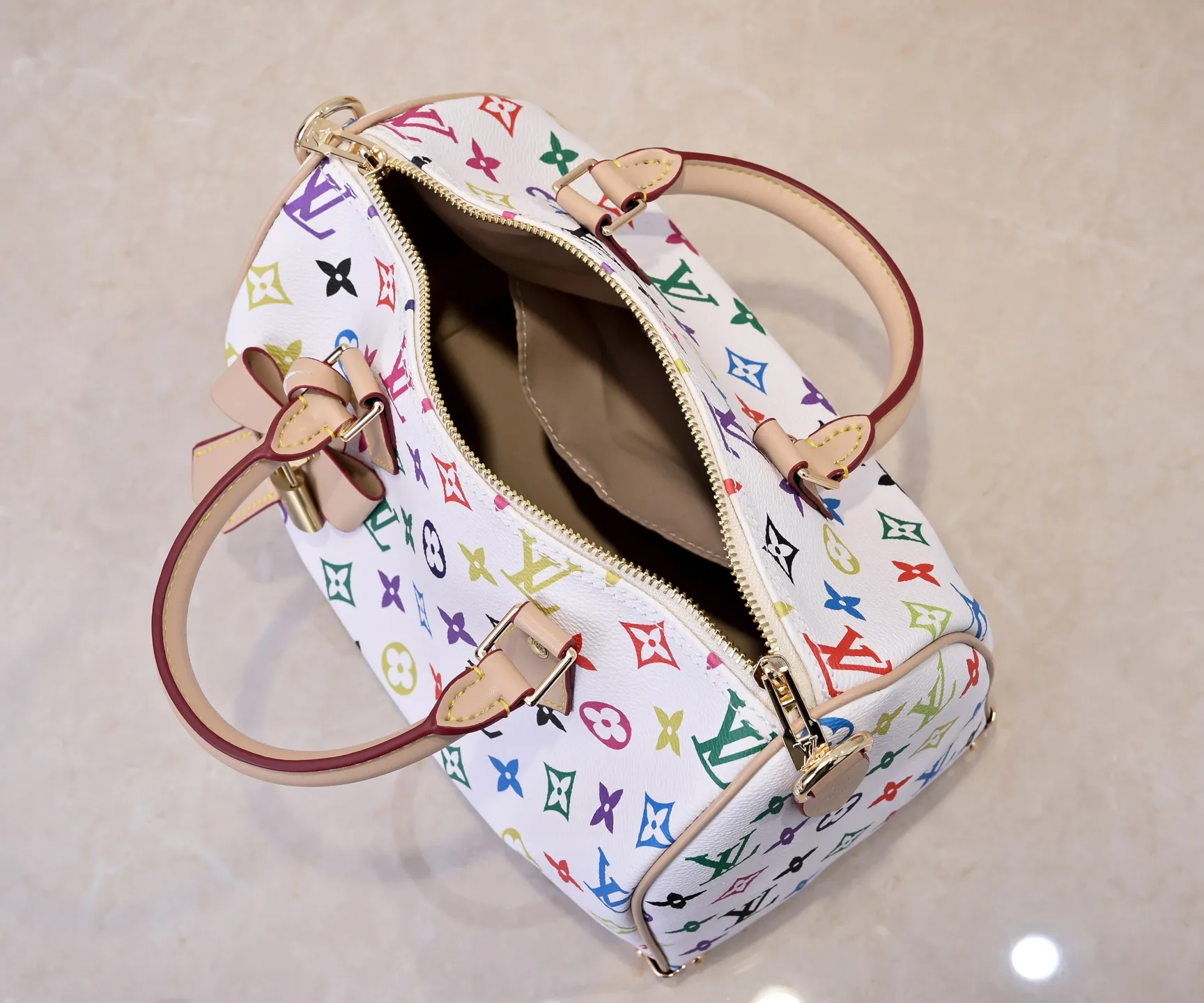 Batch 💰320 Guangzhou Product No.: M13085 40390 This Speedy Bandoulière 25 handbag uses the classic Monogram pattern to render the bright colors of Japanese artist Takashi Murakami. Together with the bow-shaped key bag, it highlights the smart style of the Louis Vuitton x Murakami collaboration series. The Toron handle and detachable and adjustable shoulder strap are fashioned from cow leather, and the dazzling padlock and corners reference the brand's luggage elements. 25 cm