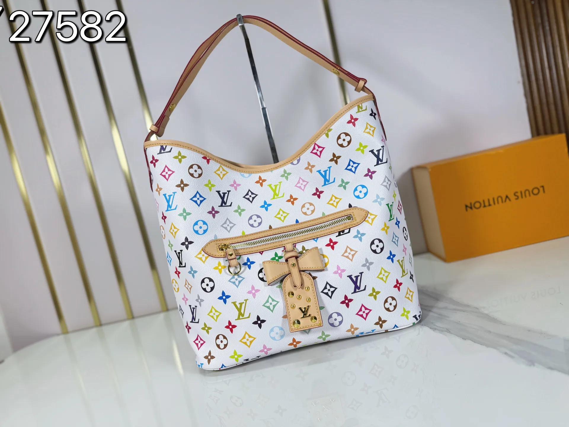 P260 M27582 upgraded from the original version, the iconic design of the Murakami series. The bag is made of smooth cotton-paved leather and is embossed with the brand's Monogram pattern. The iconic thick chain strap is paired with gold-tone hardware, and the wide non-detachable textile shoulder strap can be carried in different ways. This versatile style is large enough to hold a laptop and features a removable zip pocket. Dimensions: 32.5x32.5x15cm