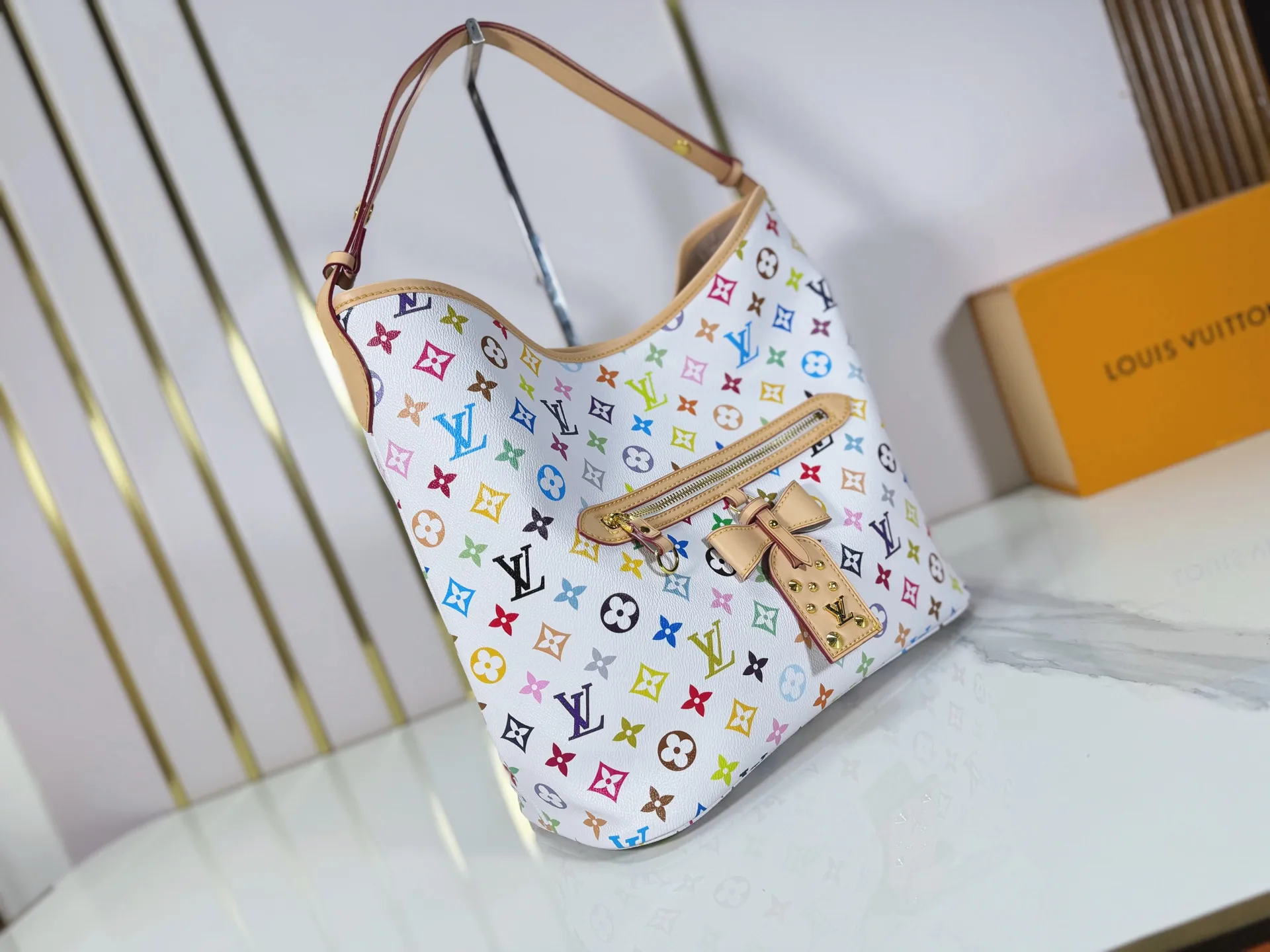 P260 M27582 upgraded from the original version, the iconic design of the Murakami series. The bag is made of smooth cotton-paved leather and is embossed with the brand's Monogram pattern. The iconic thick chain strap is paired with gold-tone hardware, and the wide non-detachable textile shoulder strap can be carried in different ways. This versatile style is large enough to hold a laptop and features a removable zip pocket. Dimensions: 32.5x32.5x15cm