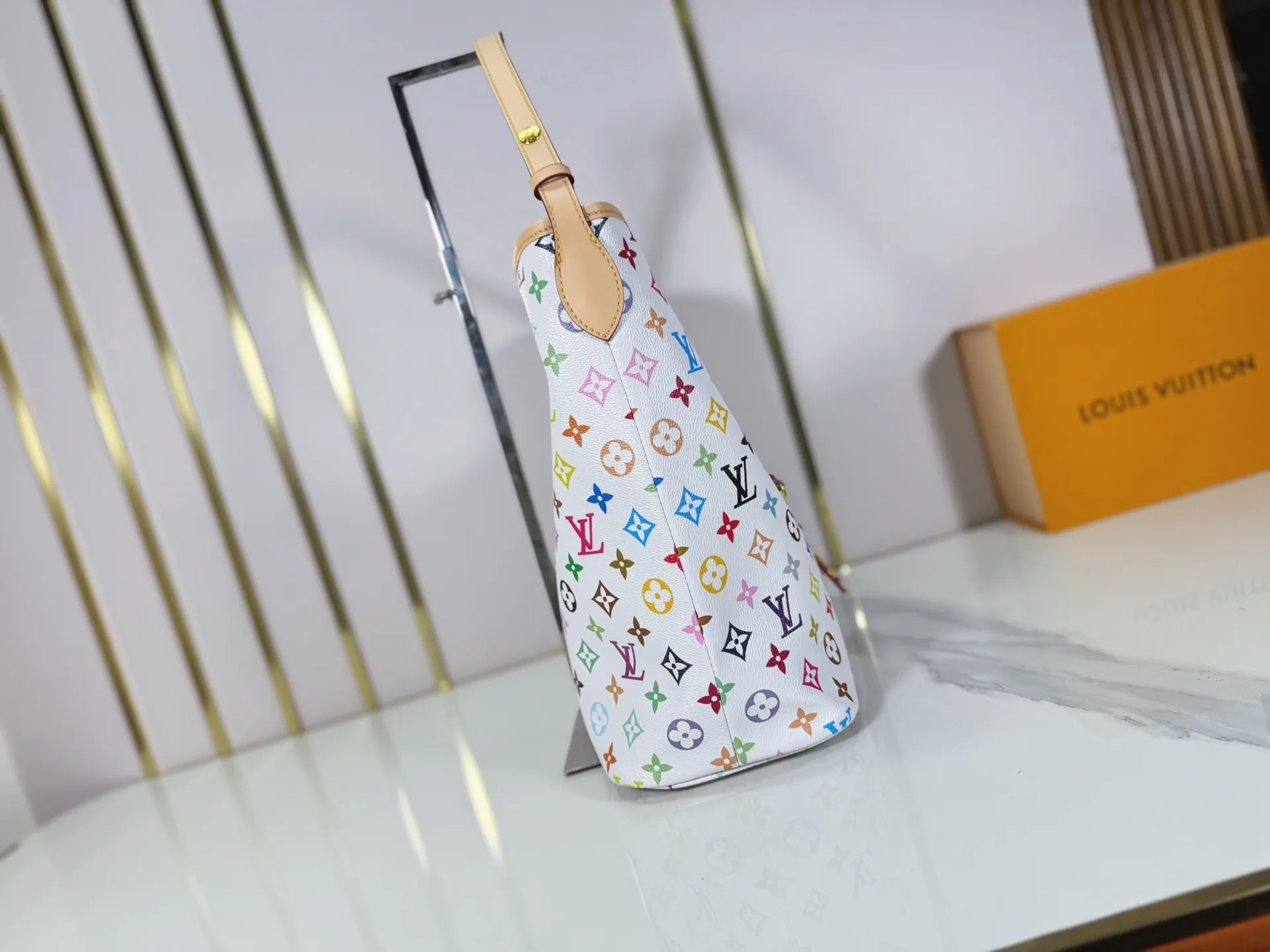 P260 M27582 upgraded from the original version, the iconic design of the Murakami series. The bag is made of smooth cotton-paved leather and is embossed with the brand's Monogram pattern. The iconic thick chain strap is paired with gold-tone hardware, and the wide non-detachable textile shoulder strap can be carried in different ways. This versatile style is large enough to hold a laptop and features a removable zip pocket. Dimensions: 32.5x32.5x15cm