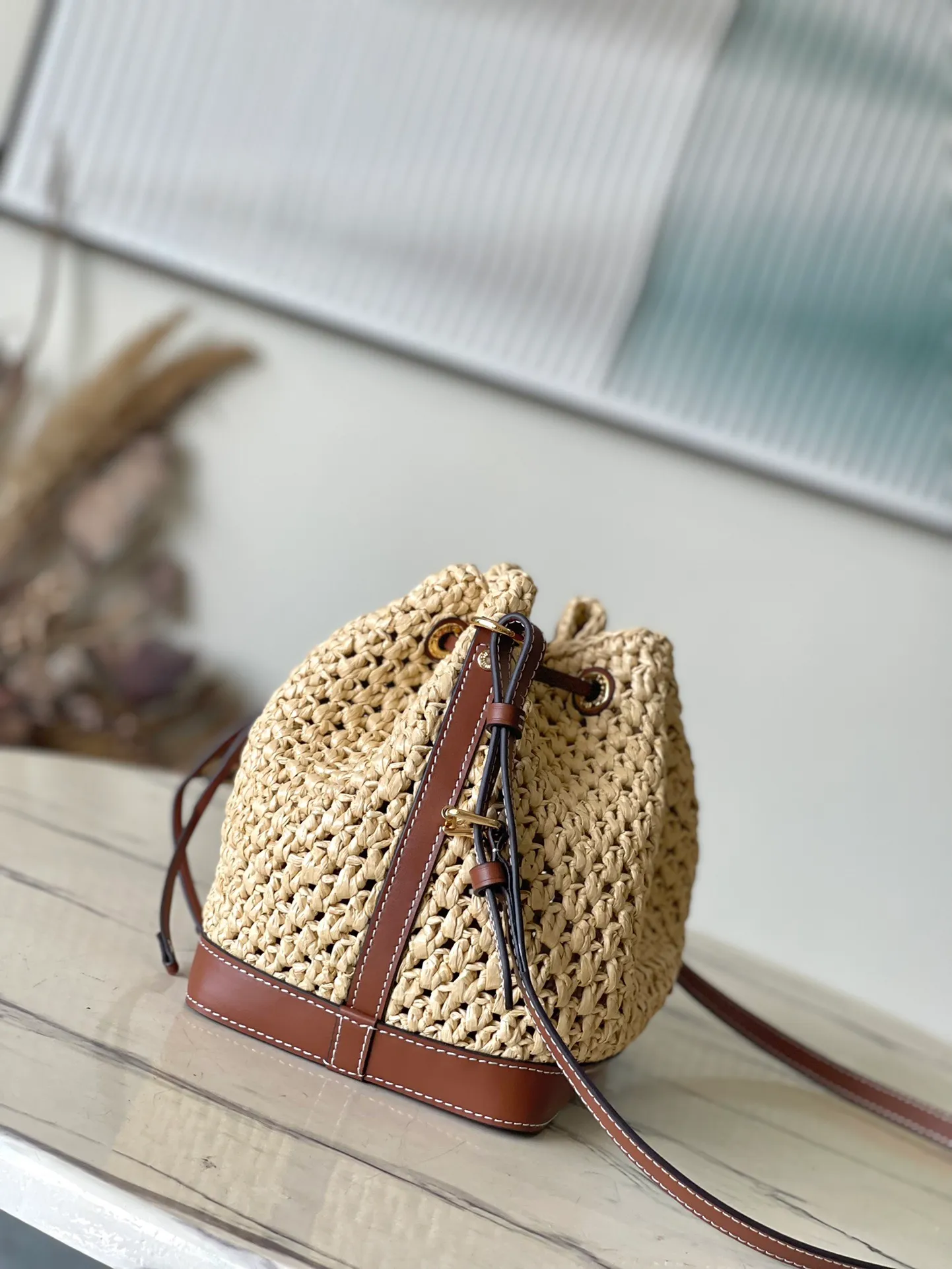💰1100 Top Original Order M24722 This NoeBB bucket bag is made of raffia crocheted by Madagascar craftsmen. It is decorated with gorgeous leather to highlight the brand's exquisite craftsmanship, achieving a comfortable texture and personalized style. Dimensions: 22 × 24 × 15 cm