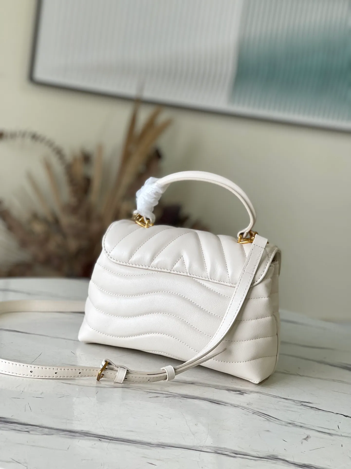 💰1180 (first-grain leather) top original order M21797 white This Hold Me handbag is a new product of its iconic New Wave quilted leather goods series, with exquisite shape and comfortable carrying. The body is smooth to the touch and features an elegant metal buckle. The removable and adjustable leather strap enhances the bag's ease of wear. Dimensions: 23 x 15 x 10 cm