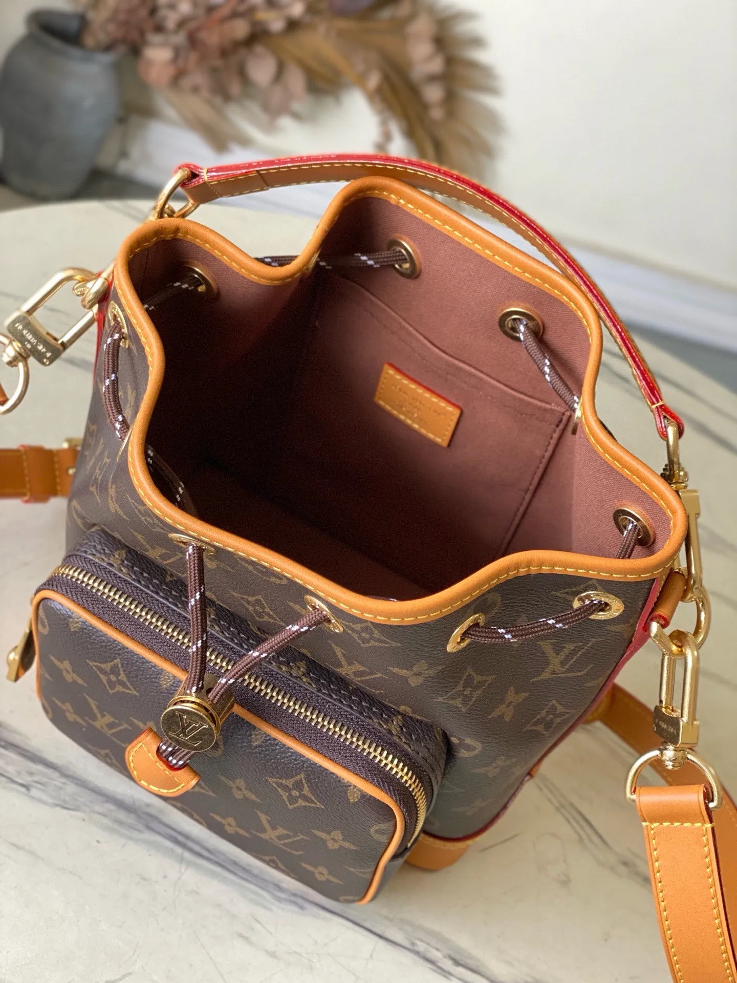 💰1200 Top original order M14017 Noe Cargo bucket bag is constructed of Monogram canvas and decorated with distressed leather trim. It inherits the Noe bucket bag designed in 1932 for carrying champagne bottles. The large front pockets and refined details nod to Louis Vuitton's rich history while meeting modern needs. The top handle and shoulder strap are detachable for flexible portability. Dimensions: 22 × 24 × 16 cm