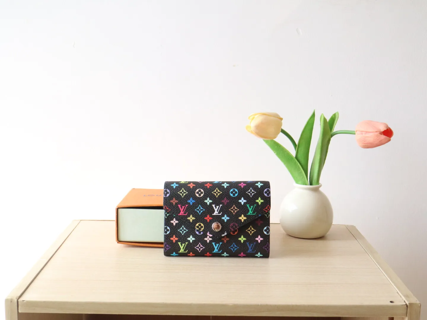14163 Tri-Color Tri-fold Wallet🌟P90 This replica version of the Victorine wallet from the Louis Vuitton x Murakami series is small and exquisite. The colorful Monogram pattern reinterprets Louis Vuitton's classic logo with the famous rainbow tones of Japanese artist Takashi Murakami. The wallet is made of coated canvas with fine cowhide lining and silver-tone hardware. It has a zippered coin compartment and multiple interior compartments for banknotes and business cards. 12 x 9.5 x 2.5 cm (length x height x width)