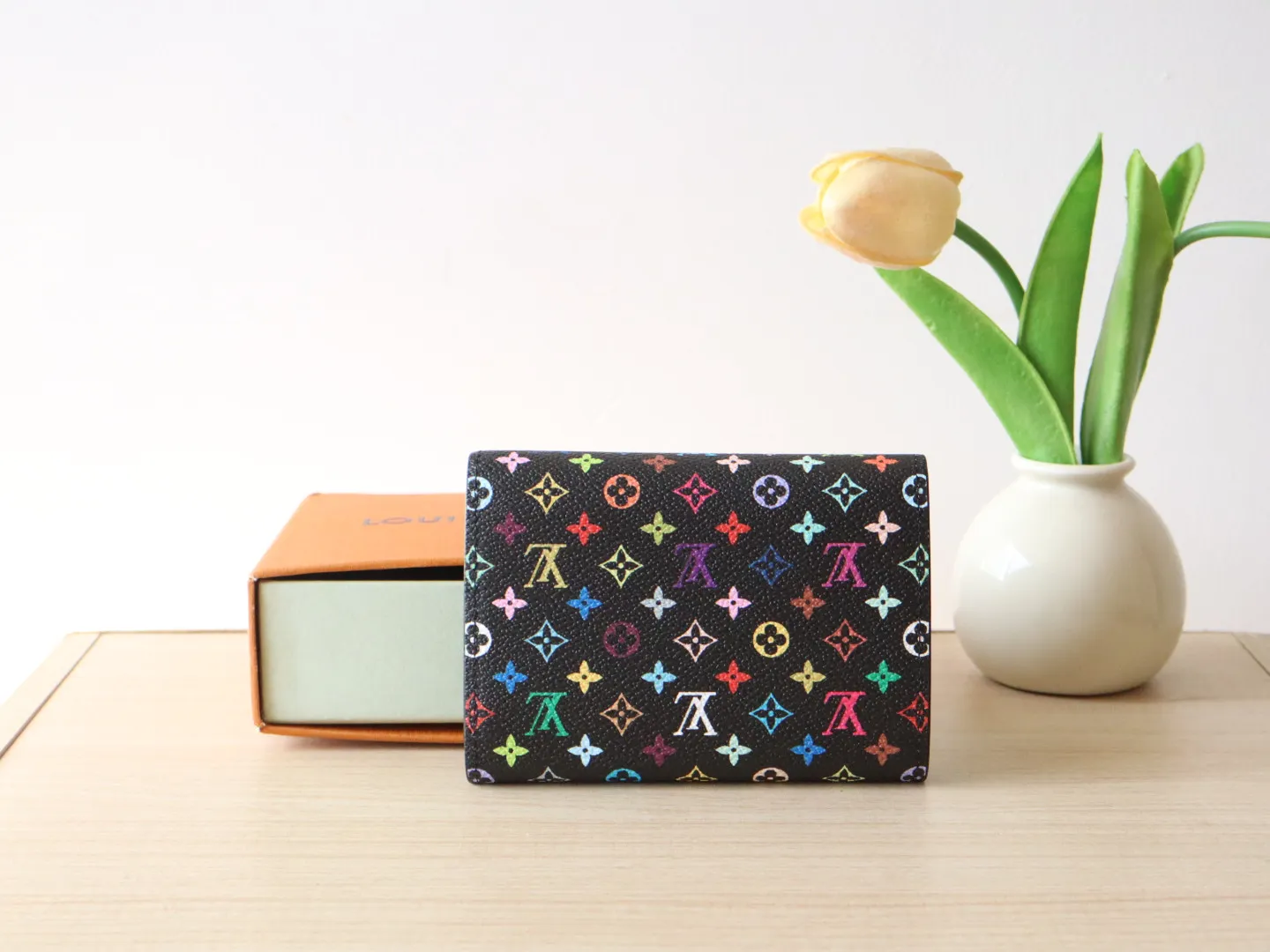 14163 Tri-Color Tri-fold Wallet🌟P90 This replica version of the Victorine wallet from the Louis Vuitton x Murakami series is small and exquisite. The colorful Monogram pattern reinterprets Louis Vuitton's classic logo with the famous rainbow tones of Japanese artist Takashi Murakami. The wallet is made of coated canvas with fine cowhide lining and silver-tone hardware. It has a zippered coin compartment and multiple interior compartments for banknotes and business cards. 12 x 9.5 x 2.5 cm (length x height x width)