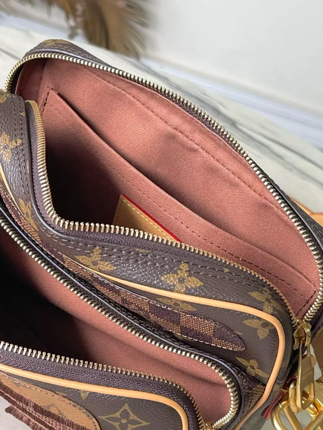 💰1280 Top Original M26068 This Nil crossbody bag is made of Monogram canvas body with Damier and Monogram Reverse canvas patches, creating an elegant collage effect. The spacious main compartment and zippered front pocket ensure easy access, while the removable top handle and shoulder strap allow for multiple carry options. 17.5 x 11 x 25 cm (height x width x length)