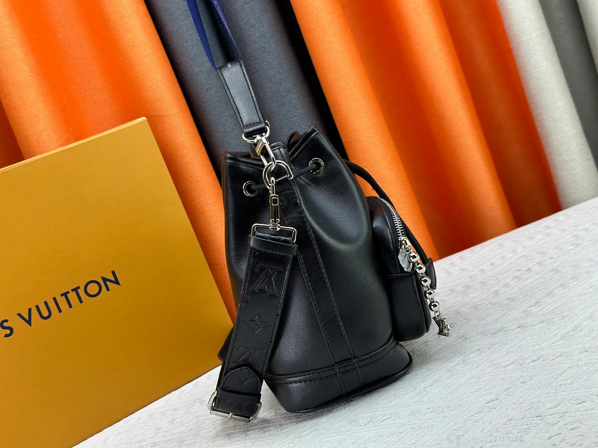 P280 Upgraded original version M13985 full leather black, official small size M14017 pure presbyopia Noe Cargo is a compact bucket bag, made of shiny cow leather, showing a nylon-like technological luster, and the lining is made of deep-toned fabric. Metal parts, including the LV letters attached to a ball chain, are the only color-coordinated elements on this monochromatic bag. Roomy front pocket inside. ·Cow leather trim fabric lined with hardware Drawstring and metal closure main compartment LV pendant zip puller ·Pearl rivets Louis Vuitton Paris patch ·Zip front pocket Shoulder strap: Removable, adjustable strap Half length: 40.0 cm Dimensions: 24✘22✘16cm (H✘L✘W)
