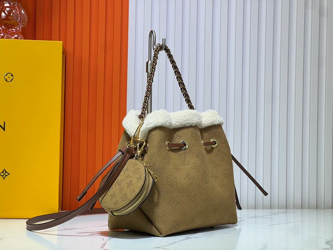 Batch 340💰Upgraded version M11839 (Cow leather digital punching process) The Bella handbag is from the LV Ski series. It is made of gorgeous engraved suede leather with shearling trim, highlighting the seasonal style with a comfortable and warm texture. The Monogram perforation pattern continues the iconic element, the chain is the finishing touch, and the round coin pocket provides secure storage. 19.0 x 22.0 x 14.0 cm (L x H x W) • Suede cow leather • Metal hardware • Round coin pocket • Metal base stud • Holds smartphone, keys, Zippy wallet and headphones • Shoulder strap: removable, adjustable • Strap half length: 50.0 cm • Strap half length adjustable to: 56.0 cm • Handle: Single handle, removable