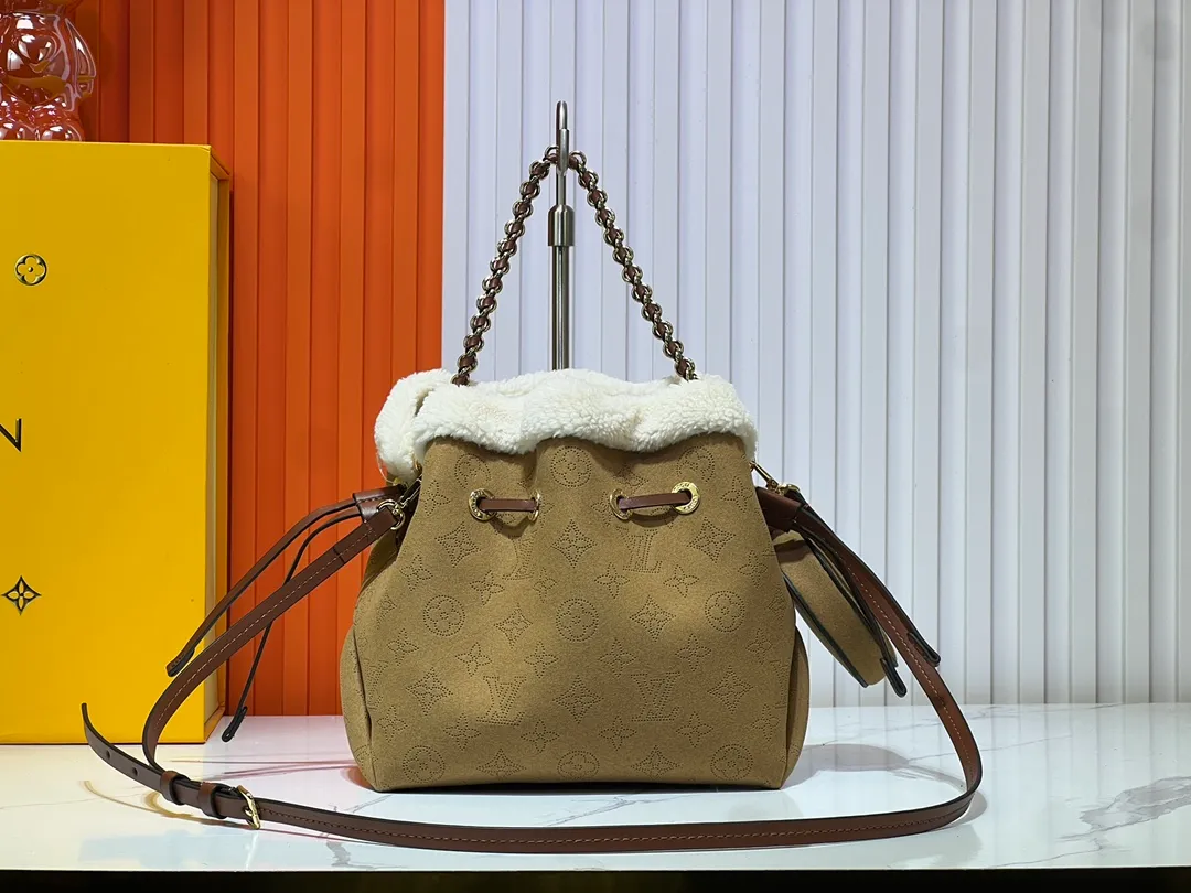Batch 340💰Upgraded version M11839 (Cow leather digital punching process) The Bella handbag is from the LV Ski series. It is made of gorgeous engraved suede leather with shearling trim, highlighting the seasonal style with a comfortable and warm texture. The Monogram perforation pattern continues the iconic element, the chain is the finishing touch, and the round coin pocket provides secure storage. 19.0 x 22.0 x 14.0 cm (L x H x W) • Suede cow leather • Metal hardware • Round coin pocket • Metal base stud • Holds smartphone, keys, Zippy wallet and headphones • Shoulder strap: removable, adjustable • Strap half length: 50.0 cm • Strap half length adjustable to: 56.0 cm • Handle: Single handle, removable