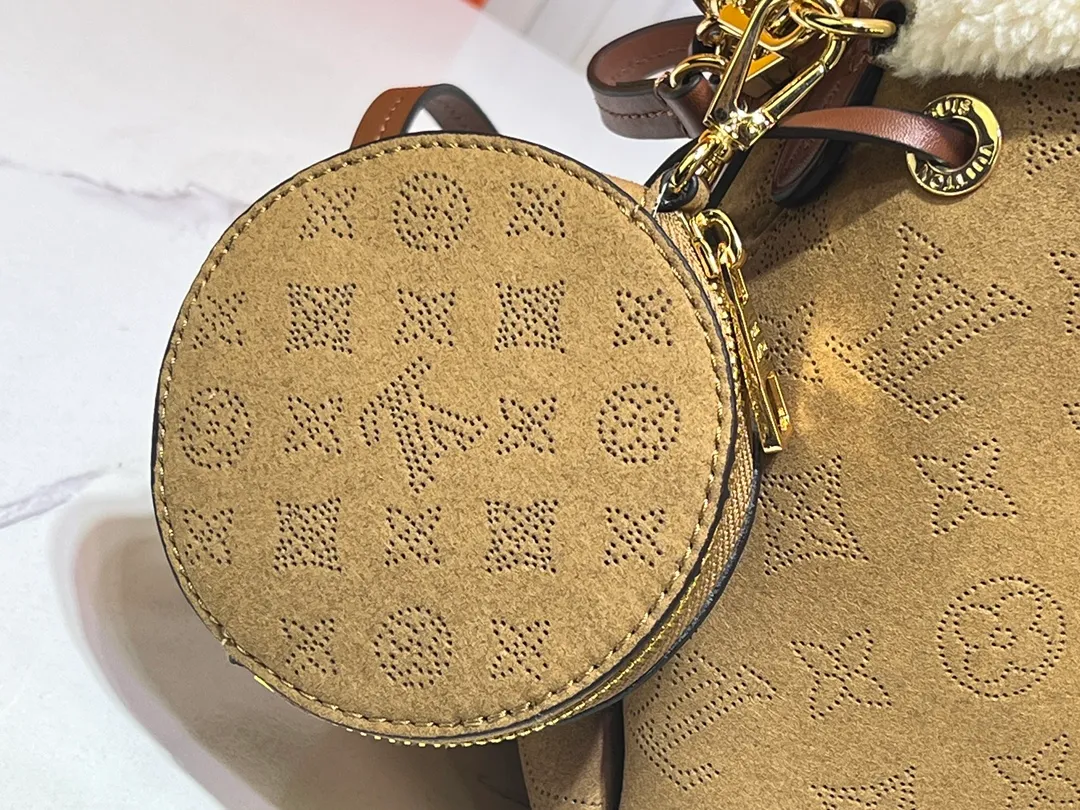 Batch 340💰Upgraded version M11839 (Cow leather digital punching process) The Bella handbag is from the LV Ski series. It is made of gorgeous engraved suede leather with shearling trim, highlighting the seasonal style with a comfortable and warm texture. The Monogram perforation pattern continues the iconic element, the chain is the finishing touch, and the round coin pocket provides secure storage. 19.0 x 22.0 x 14.0 cm (L x H x W) • Suede cow leather • Metal hardware • Round coin pocket • Metal base stud • Holds smartphone, keys, Zippy wallet and headphones • Shoulder strap: removable, adjustable • Strap half length: 50.0 cm • Strap half length adjustable to: 56.0 cm • Handle: Single handle, removable