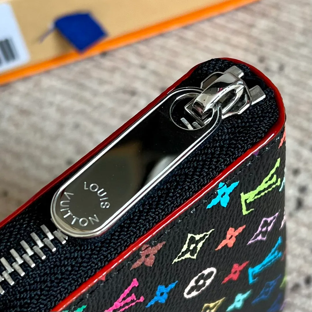 Factory Price 300 Top Original LV x TM Zippy Coin Purse M13409 Black Color (Three Colors - Murakami Takashi) As part of the Louis Vuitton x Murakami series reissue, the timeless Zippy coin purse is practical and playful, upgraded for this season. It's made from Monogram coated canvas in a cheerful rainbow of hues, in keeping with the Japanese artist's signature pop palette. The interior is secured with a silver zipper and is divided into multiple compartments for coins, banknotes and cards. Dimensions: 11 x 8.5 x 2 cm.