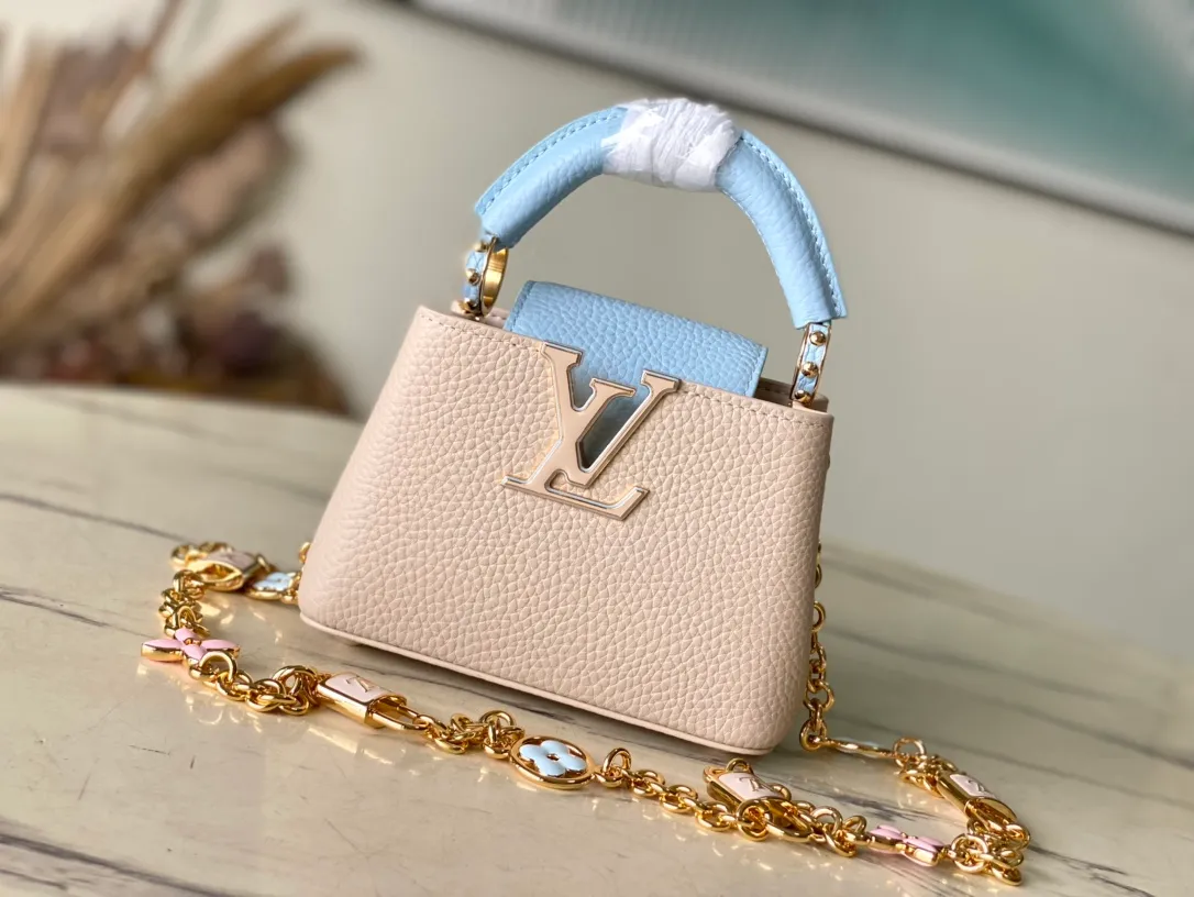 💰2000 (Special Original Leather) M23952 nano This Capucines nano handbag comes from the Lovelock Chain series. The Taurillon leather bag has a dotted rope that looks like a jewelry chain, with a padlock and pastel enamel Monogram flowers, echoing the dual tones of the leather. The detachable chain and top handle provide more carrying options, and the inner pocket is equipped with a small mirror for easy touch-ups at any time. Dimensions: 16.3 × 11 × 6.5 cm