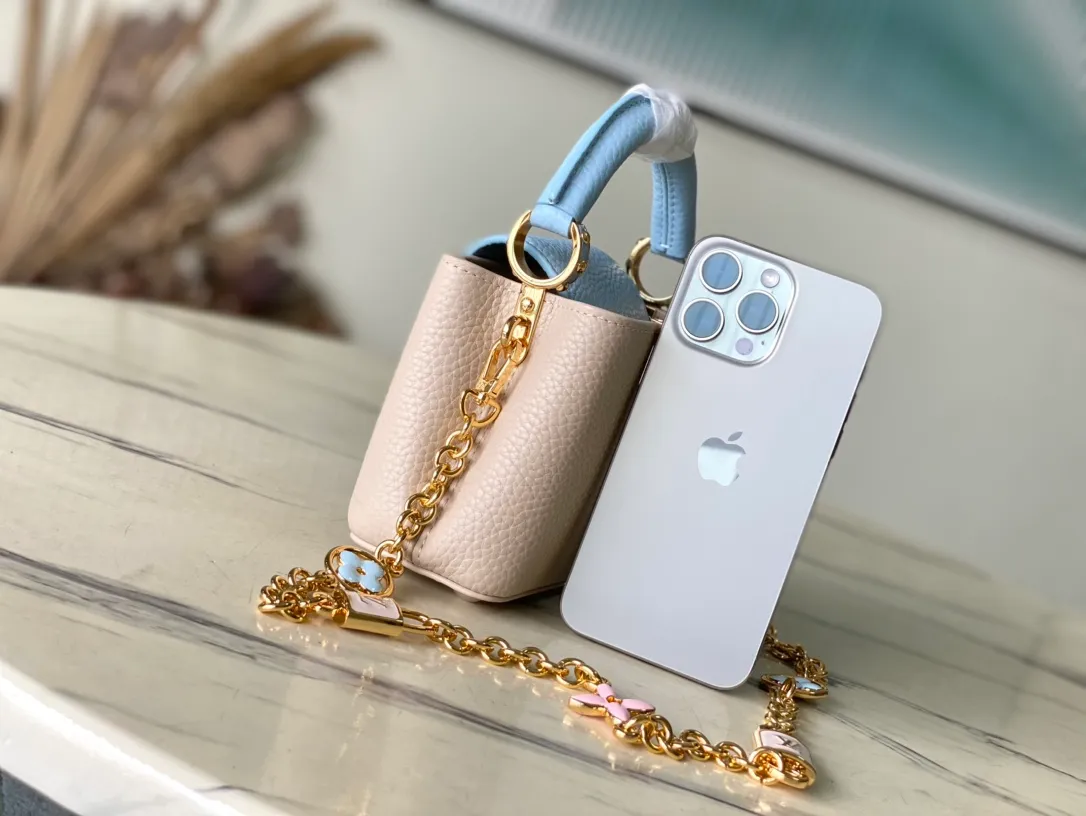 💰2000 (Special Original Leather) M23952 nano This Capucines nano handbag comes from the Lovelock Chain series. The Taurillon leather bag has a dotted rope that looks like a jewelry chain, with a padlock and pastel enamel Monogram flowers, echoing the dual tones of the leather. The detachable chain and top handle provide more carrying options, and the inner pocket is equipped with a small mirror for easy touch-ups at any time. Dimensions: 16.3 × 11 × 6.5 cm