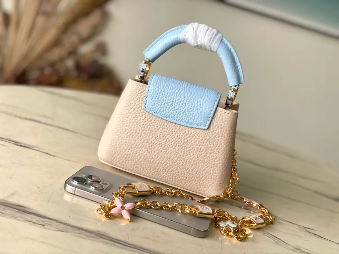 💰2000 (Special Original Leather) M23952 nano This Capucines nano handbag comes from the Lovelock Chain series. The Taurillon leather bag has a dotted rope that looks like a jewelry chain, with a padlock and pastel enamel Monogram flowers, echoing the dual tones of the leather. The detachable chain and top handle provide more carrying options, and the inner pocket is equipped with a small mirror for easy touch-ups at any time. Dimensions: 16.3 × 11 × 6.5 cm