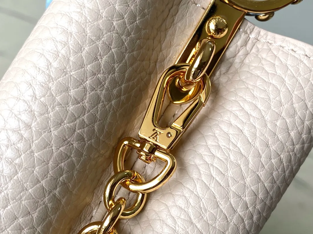 💰2000 (Special Original Leather) M23952 nano This Capucines nano handbag comes from the Lovelock Chain series. The Taurillon leather bag has a dotted rope that looks like a jewelry chain, with a padlock and pastel enamel Monogram flowers, echoing the dual tones of the leather. The detachable chain and top handle provide more carrying options, and the inner pocket is equipped with a small mirror for easy touch-ups at any time. Dimensions: 16.3 × 11 × 6.5 cm