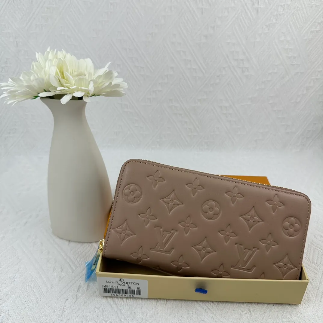 P130 M81511 Apricot Sewn with padded Monogram embossed lambskin, it complements the Coussin leather boutique series. Beautifully designed with a gold-tone zipper embossed with the LV Circle signature pull, the interior of the all-in-one wallet is packed with practical features, including three large compartments, a coin compartment and 12 business card slots. Dimensions: 19.5 x 10.5 x 2.5 cm