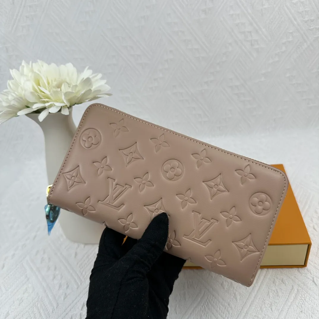 P130 M81511 Apricot Sewn with padded Monogram embossed lambskin, it complements the Coussin leather boutique series. Beautifully designed with a gold-tone zipper embossed with the LV Circle signature pull, the interior of the all-in-one wallet is packed with practical features, including three large compartments, a coin compartment and 12 business card slots. Dimensions: 19.5 x 10.5 x 2.5 cm