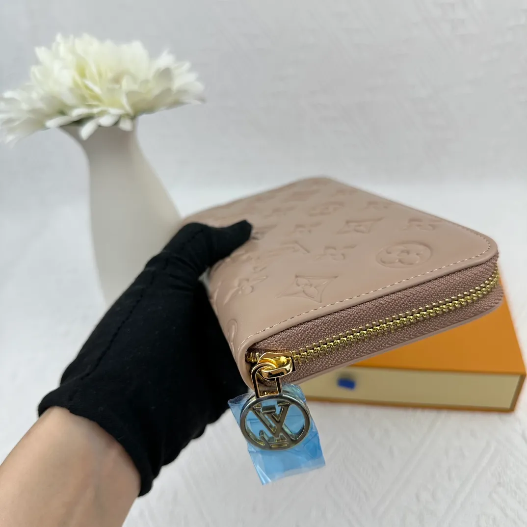P130 M81511 Apricot Sewn with padded Monogram embossed lambskin, it complements the Coussin leather boutique series. Beautifully designed with a gold-tone zipper embossed with the LV Circle signature pull, the interior of the all-in-one wallet is packed with practical features, including three large compartments, a coin compartment and 12 business card slots. Dimensions: 19.5 x 10.5 x 2.5 cm