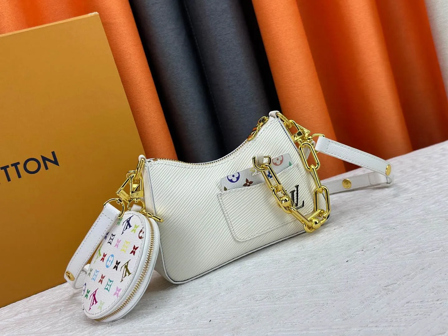 P260 M13099 This Marellini handbag is made of rich-texture Epi leather to create a delicate structure with ample space to store daily necessities such as smartphones. The round coin purse and mirror are both made of the colorful Monogram canvas from the Louis Vuitton x Takashi Murakami collaboration series, and are fixed to the bag body with a rough metal chain. Size: 19x13.5x6.5cm