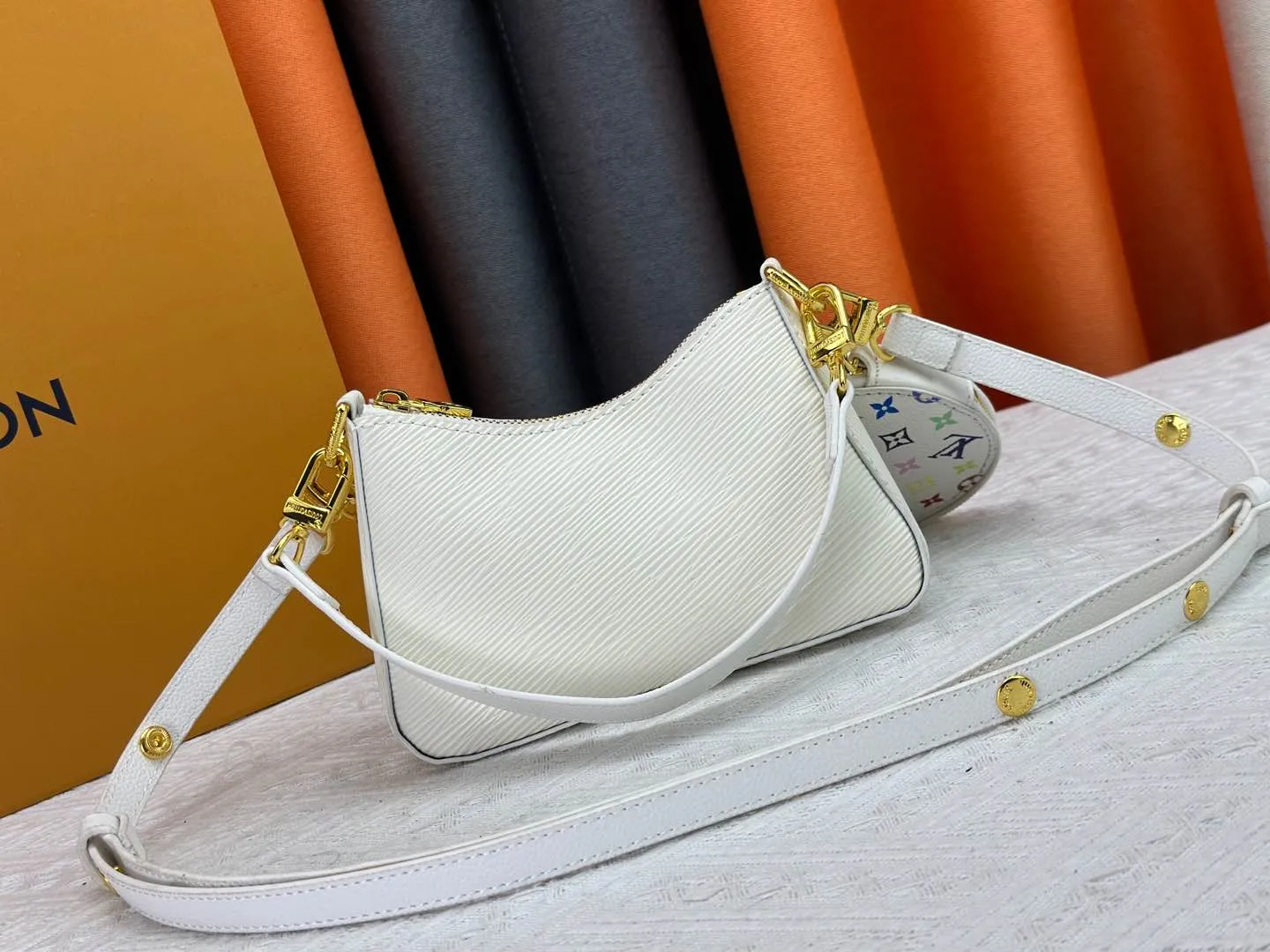 P260 M13099 This Marellini handbag is made of rich-texture Epi leather to create a delicate structure with ample space to store daily necessities such as smartphones. The round coin purse and mirror are both made of the colorful Monogram canvas from the Louis Vuitton x Takashi Murakami collaboration series, and are fixed to the bag body with a rough metal chain. Size: 19x13.5x6.5cm