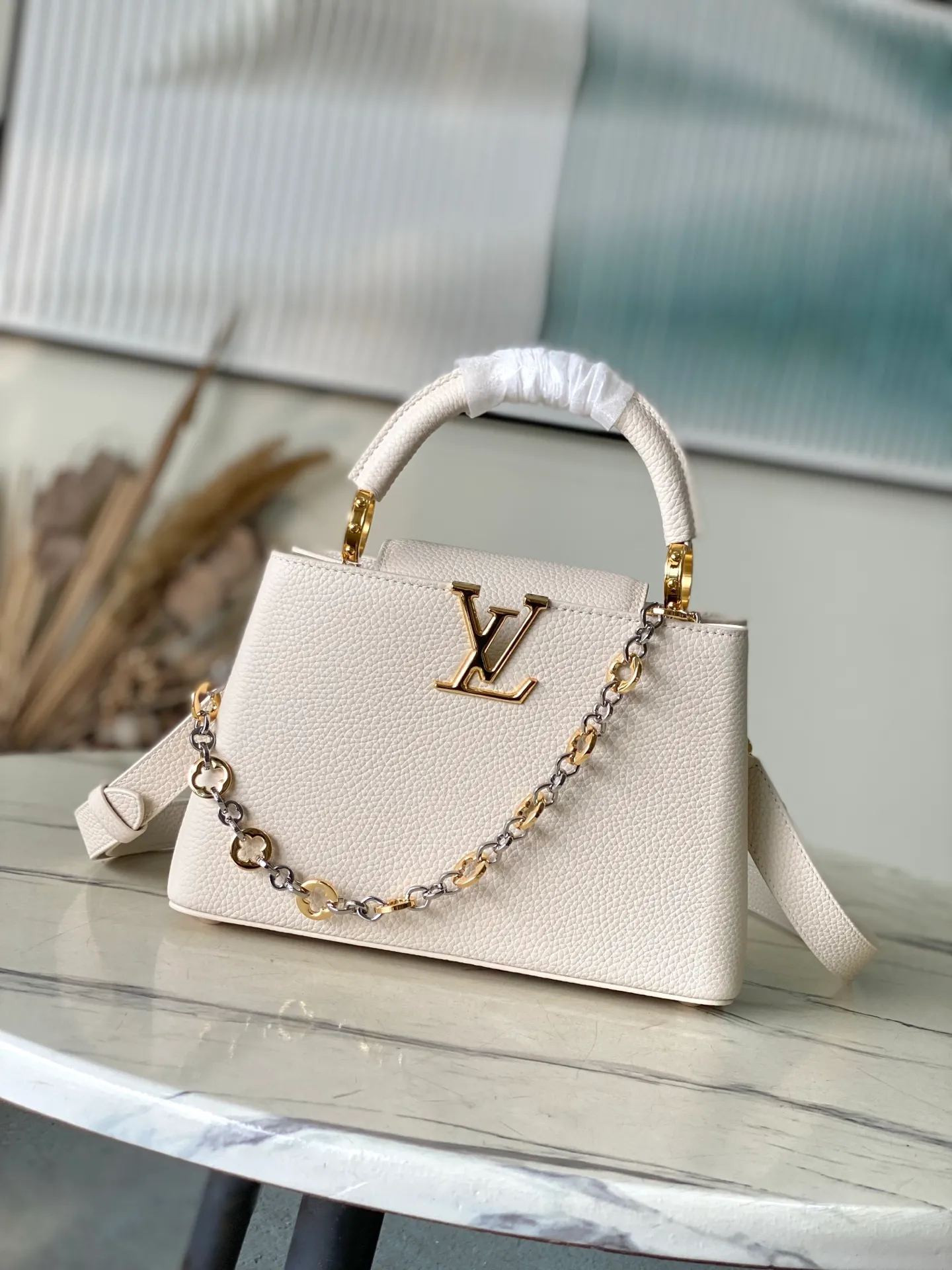 💰2380 "Special Grade Original Leather" M12935 Milk White Small Size This Capucines BB handbag is made of flexible Taurillon cow leather. It uses jewelry-style double-plated chains and Monogram floral elements to highlight the identity of the Chain On You series. The flip cover can be placed on both the inside and outside. The ample structure and multiple inner pockets are convenient for storing daily needs. The rounded V letter adds an ingenious detail. Dimensions: 27 × 18 × 9 cm