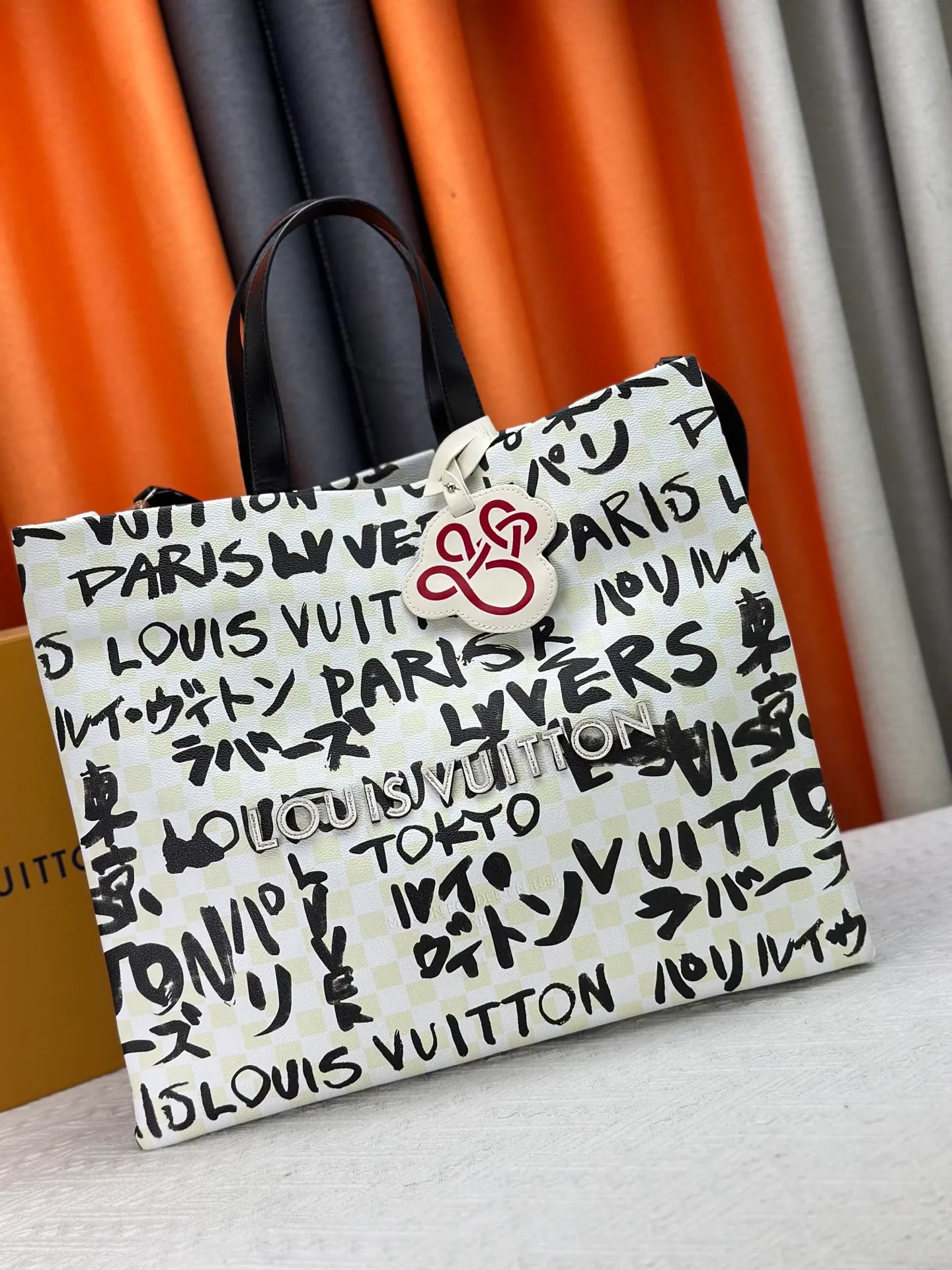 P300 M24457 M40797 This Shopper Tote medium handbag features Damier checkerboard pattern superimposed with eye-catching hand-painted elements, witnessing the joint creativity of Pharrell Williams and Japanese designer Nigo. The names Louis Vuitton, Paris and Tokyo, as well as the word Lvvers, are bilingual in French and Japanese, and the graphic cotton lining showcases Nigo's signature style. Size: 41x34x16cm