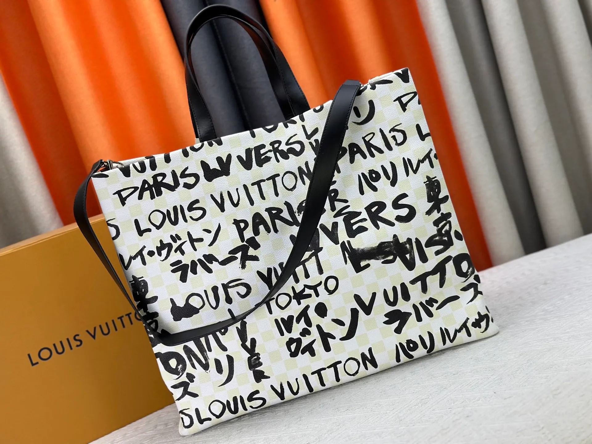 P300 M24457 M40797 This Shopper Tote medium handbag features Damier checkerboard pattern superimposed with eye-catching hand-painted elements, witnessing the joint creativity of Pharrell Williams and Japanese designer Nigo. The names Louis Vuitton, Paris and Tokyo, as well as the word Lvvers, are bilingual in French and Japanese, and the graphic cotton lining showcases Nigo's signature style. Size: 41x34x16cm