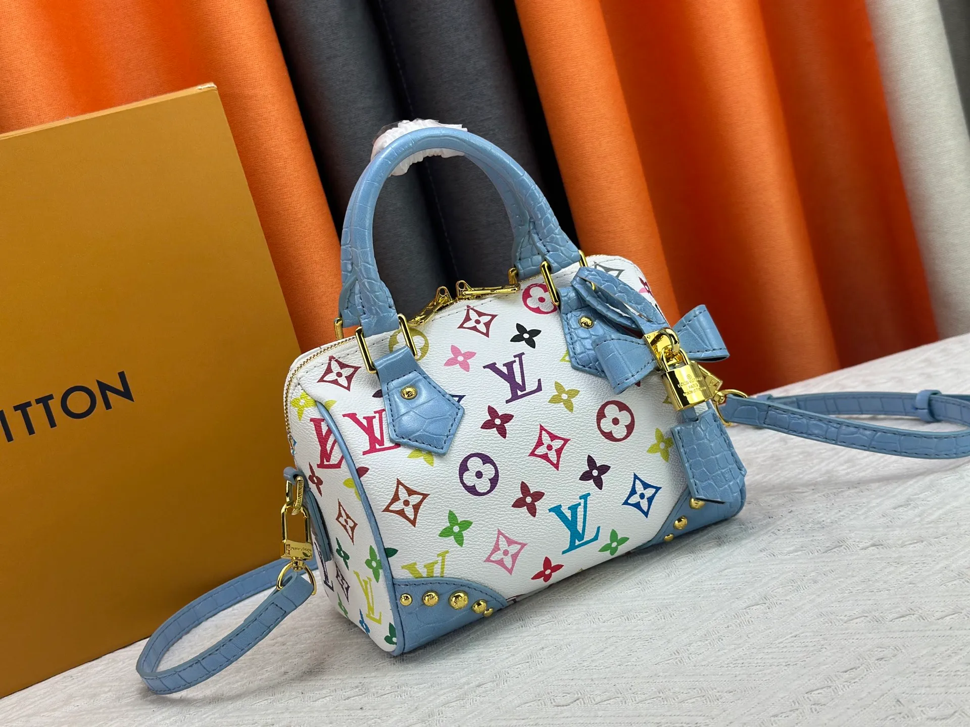 P260 Upgraded original crocodile pattern M13365 M58953 M46234 M46222 Speedy Bandoulière 20 handbag is made of soft coated canvas, and the full-length Monogram pattern is traced in colorful rainbow tones, highlighting the smart style of the Louis Vuitton x Murakami reissue series. The Toron handle and detachable shoulder strap are constructed of cow leather, the metal corners recall classic luggage elements, and the bow-shaped key bag and padlock add brand touches. Dimensions: 20.5 x 13.5 x 12.0 cm (length x height x width)