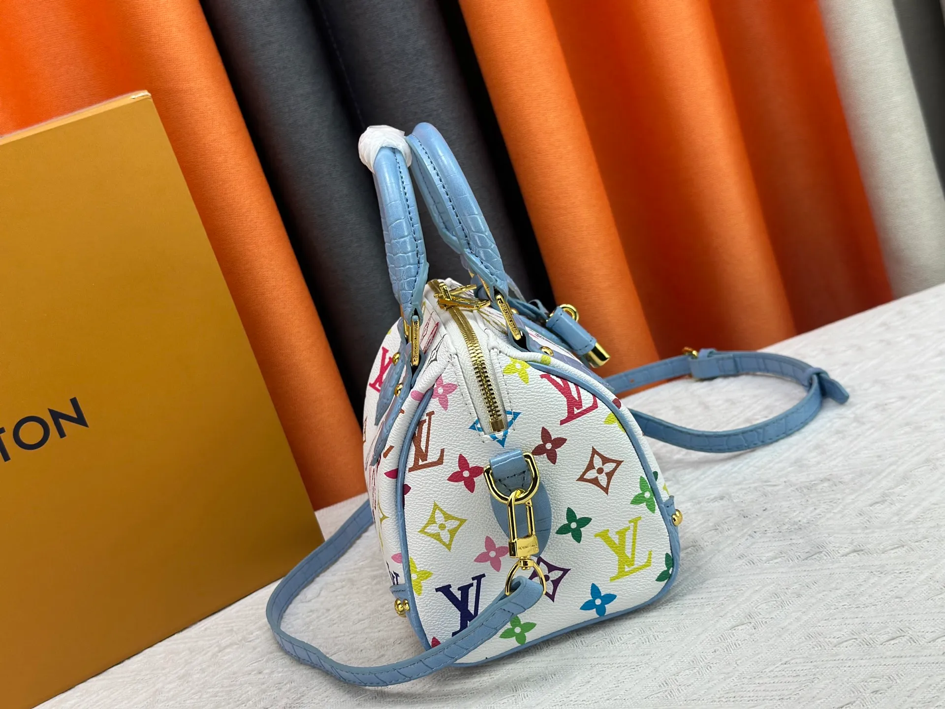 P260 Upgraded original crocodile pattern M13365 M58953 M46234 M46222 Speedy Bandoulière 20 handbag is made of soft coated canvas, and the full-length Monogram pattern is traced in colorful rainbow tones, highlighting the smart style of the Louis Vuitton x Murakami reissue series. The Toron handle and detachable shoulder strap are constructed of cow leather, the metal corners recall classic luggage elements, and the bow-shaped key bag and padlock add brand touches. Dimensions: 20.5 x 13.5 x 12.0 cm (length x height x width)