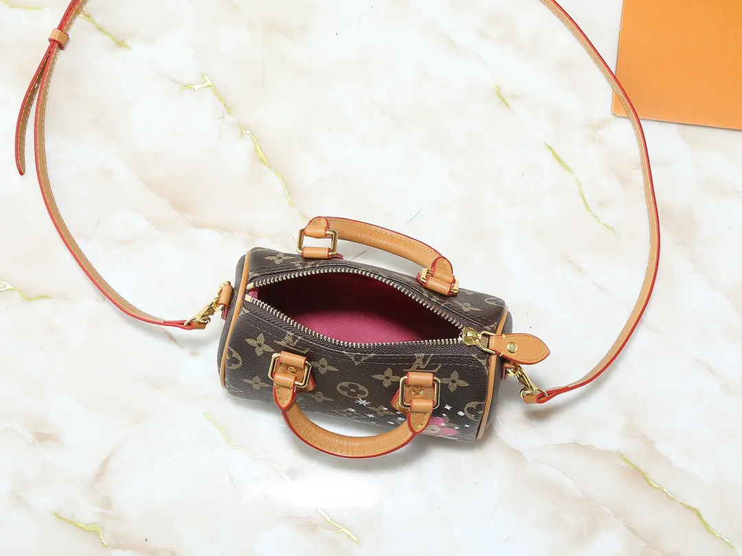 💰180💰Upgraded original [NANO SPEEDY handbag] M81085 m82624 Presbyopia/pink (silk screen) Christmas model This Nano Speedy handbag combines Monogram canvas and distressed cow leather trim, condensing the classic configuration of the Speedy travel bag in the 1930s. The body of the bag features the brand's mascot, Vivienne, in a joyful and gliding image. The fabric lining reflects her petals, and it has top handles and a detachable and adjustable shoulder strap.  Dimensions: 16 x 10 x 7.5 cm