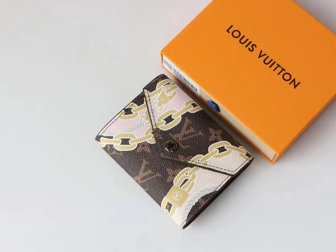 P130, M40468 Chic "Portefeuille Victorine" in printed canvas. Damier Azur canvas is combined with marine-inspired patterns in feminine rope and chain tones. Small flap wallet with three pockets and six card slots, fastened with gold-tone snap buttons and engraved Louis Vuitton signature. Size: 12*9.5*1.5cm