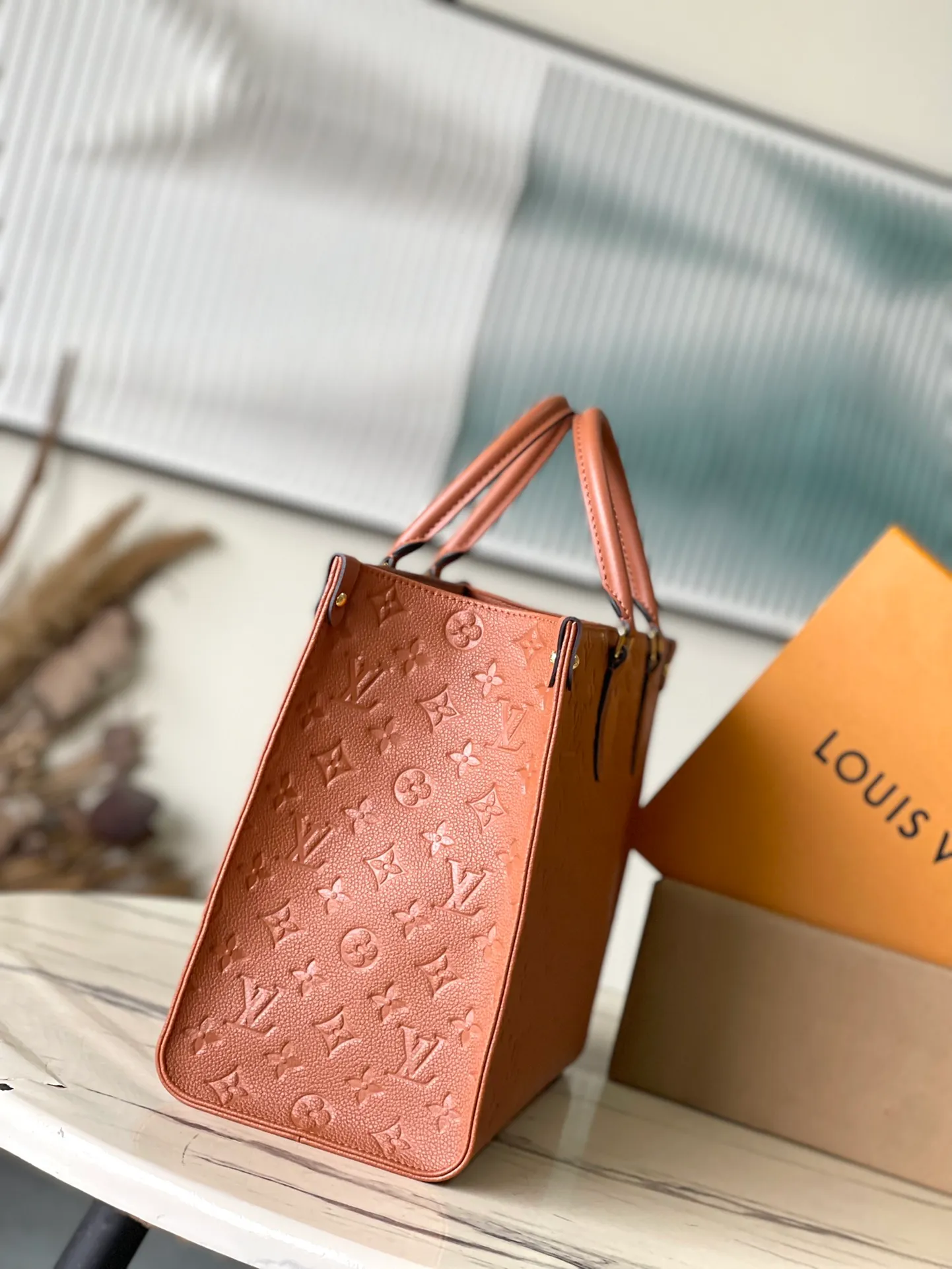 💰1140 (top-grain leather) Top-quality original order M12775 This medium-sized OnTheGo handbag is inspired by retro hard cases. The brand's iconic Monogram Empreinte leather is dyed with rich colors and matched with exquisite metal parts. The ample structure can accommodate a 13-inch laptop, and there are multiple inner pockets for convenient storage of items. Long and short handles enable multiple carrying methods. Dimensions: 35 × 27 × 14 cm