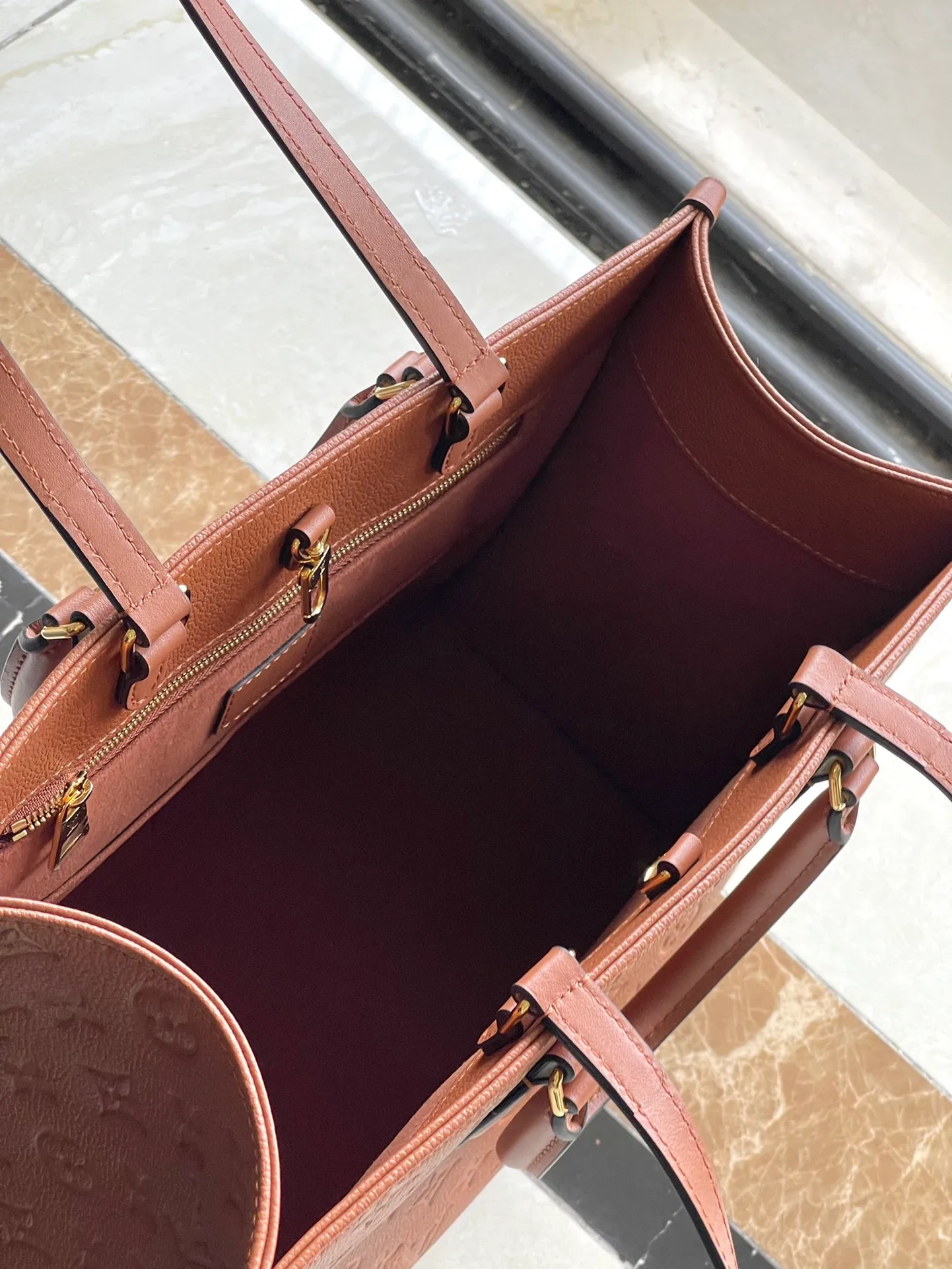 💰1140 (top-grain leather) Top-quality original order M12775 This medium-sized OnTheGo handbag is inspired by retro hard cases. The brand's iconic Monogram Empreinte leather is dyed with rich colors and matched with exquisite metal parts. The ample structure can accommodate a 13-inch laptop, and there are multiple inner pockets for convenient storage of items. Long and short handles enable multiple carrying methods. Dimensions: 35 × 27 × 14 cm