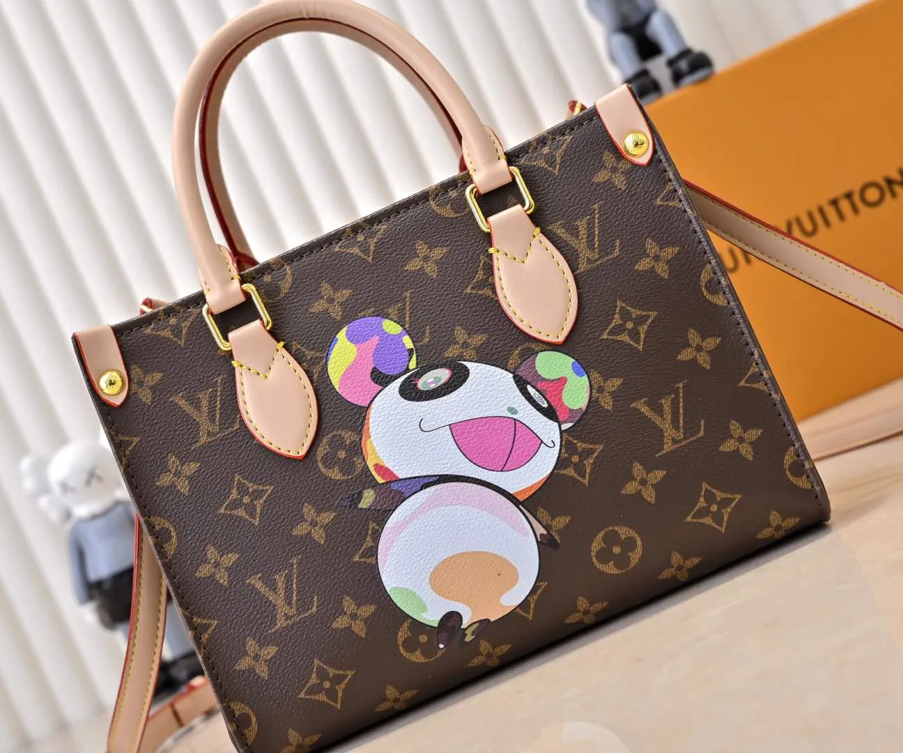Batch 300💰M45659 M13668!🔥Lv&Takashi Murakami🐼Panda print OnTheGo small new version The legendary ONTHEGO handbag: always able to meet your various needs for handbags. It has a large capacity but is not bulky. It is stiff and soft to the touch, making it suitable for home and travel. Tighten the side ties and it instantly transforms into a stylish urban handbag. Loosen the straps and it transforms into a chic and practical handbag. The slender leather handle can be carried over the shoulder or between the arms. The model shown here is made of Damier Azur canvas. Size: 25x11x19cm