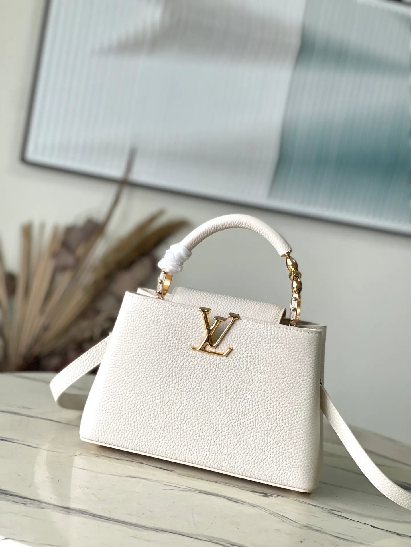 💰2360 (special grade original leather) M23944 small white size. This Capucines BB handbag is made of Taurillon cow leather embellished with shiny metal parts, and the LV letters are written with 3D strokes. Metal Monogram flowers bloom quietly on the rolled leather handle, subtly proving the brand's exquisite craftsmanship. The detachable and adjustable leather shoulder strap allows for comfortable shoulder carrying. Dimensions: 26.5 × 17.5 × 9 cm
