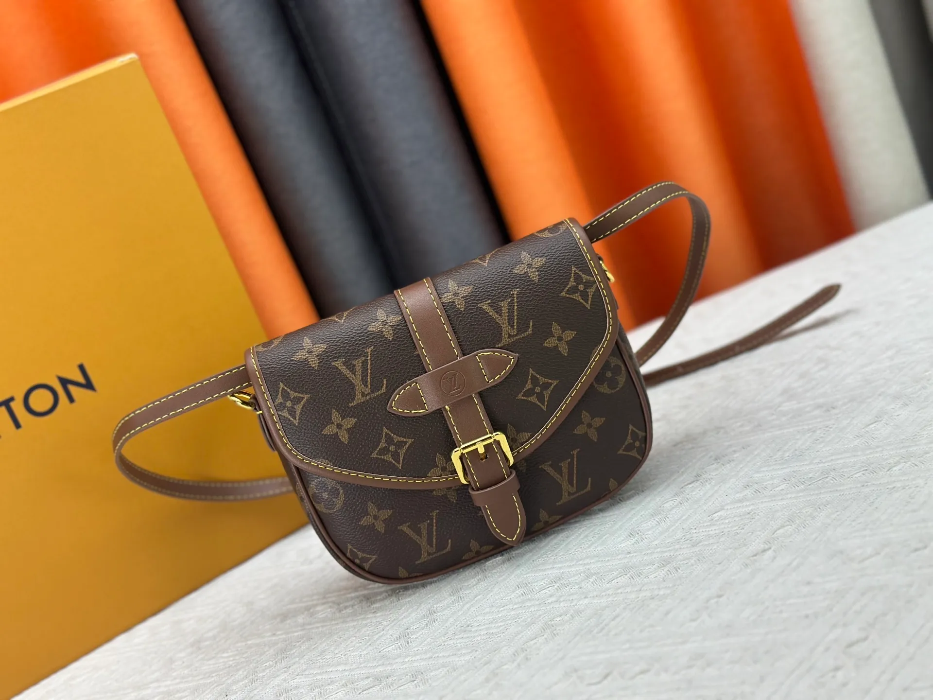 P300 upgrades the original M26592 2025 autumn and winter new Duo BB handbag with a new silhouette, integrating chic design with modern style. This fun accessory reinterprets the Saumur bag's classic shape in the brand's signature Monogram canvas with contrasting calfskin trim and an adjustable shoulder strap. It can be worn around the waist, with two compartments on either side of the hip, or it can be split into two separate handbags. Metal parts add a refined touch. Dimensions: 19 x 14 x 6 (cm) ((length x height x width)