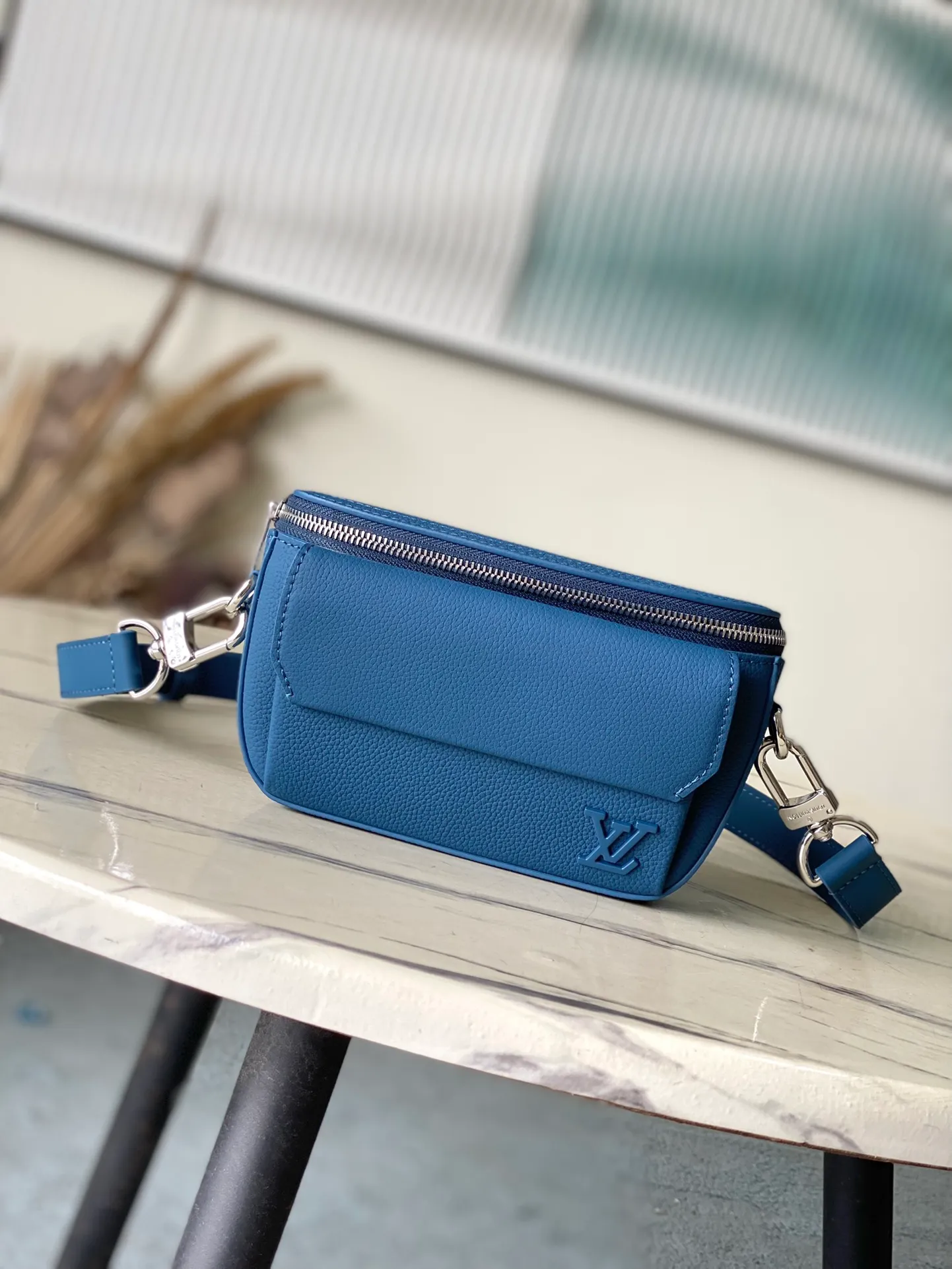 💰940 (top layer leather) top original order M83563 blue. This Pilot mini handbag is made of grained cow leather with a round shape, providing a trendy choice for daily travel. A zippered main compartment ensures secure storage, and a front pocket provides easy access to small items like your phone or keys. Detachable shoulder strap allows for comfortable shoulder or cross-body wear. Dimensions: 20 × 12 × 5,5 cm