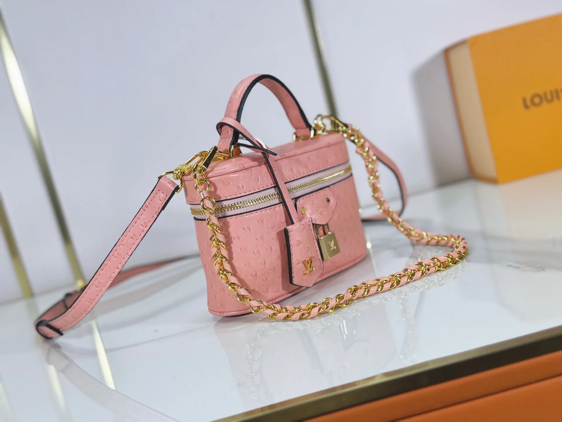 P240 M85911 M85820 M47125 Ostrich leather Vanity Chain Pouch cosmetic box chain bag is inspired by traditional cosmetic boxes and embodies the spirit of travel. This refined, slim bag is trimmed with goatskin trim on the top handle and features a removable braided chain. It is known for its rich collection of iconic details, including LV engraved padlocks and ostrich leather key bells. size：19x11x.5x6.5cm