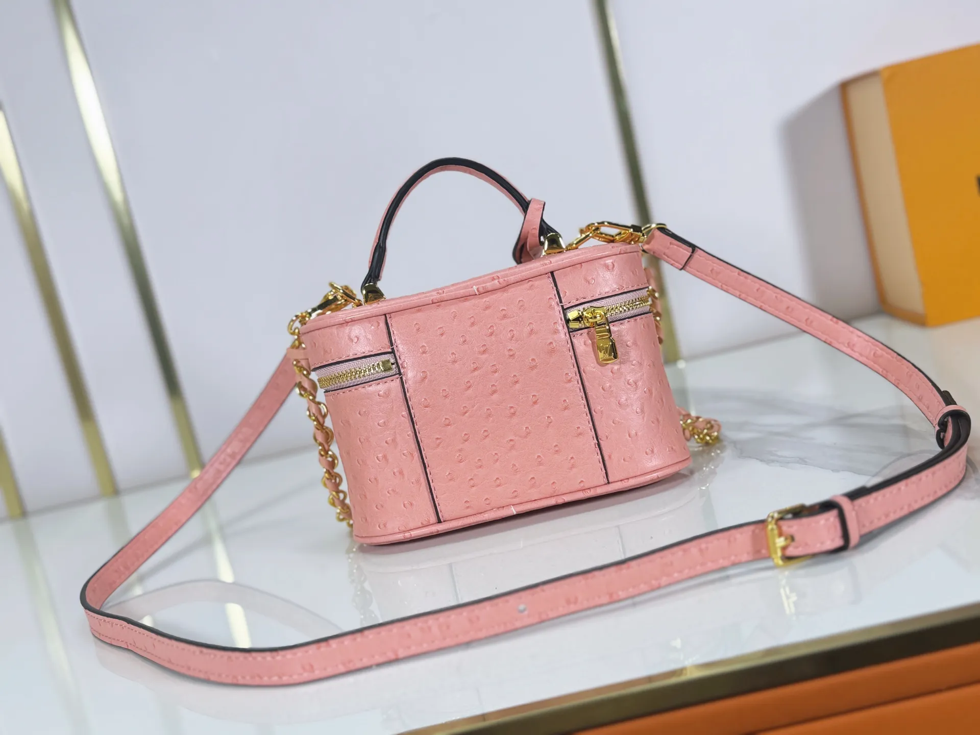 P240 M85911 M85820 M47125 Ostrich leather Vanity Chain Pouch cosmetic box chain bag is inspired by traditional cosmetic boxes and embodies the spirit of travel. This refined, slim bag is trimmed with goatskin trim on the top handle and features a removable braided chain. It is known for its rich collection of iconic details, including LV engraved padlocks and ostrich leather key bells. size：19x11x.5x6.5cm