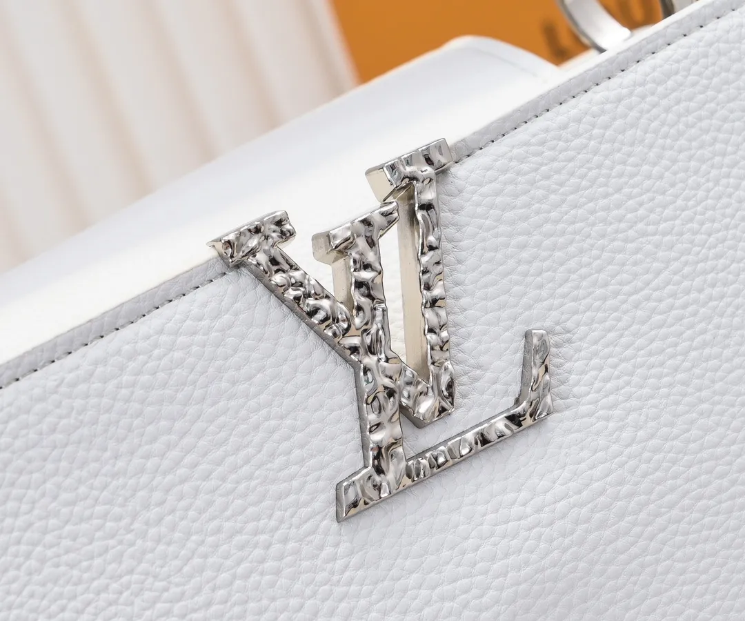 Upgraded version P440 M24664 This medium-sized CapucinesEastWest handbag is from the LVCrush series, with eye-catching forged LV letters lighting up the grained cow leather body. The rolled leather top handle allows for hand or elbow carry, and the adjustable and removable spaghetti strap makes it easy to carry over the shoulder. Personalized Gift Detailed Features 33 x 19 x 9 cm (Length x Height x Width)