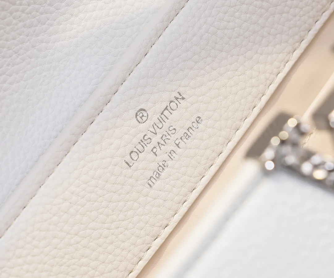 Upgraded version P440 M24664 This medium-sized CapucinesEastWest handbag is from the LVCrush series, with eye-catching forged LV letters lighting up the grained cow leather body. The rolled leather top handle allows for hand or elbow carry, and the adjustable and removable spaghetti strap makes it easy to carry over the shoulder. Personalized Gift Detailed Features 33 x 19 x 9 cm (Length x Height x Width)