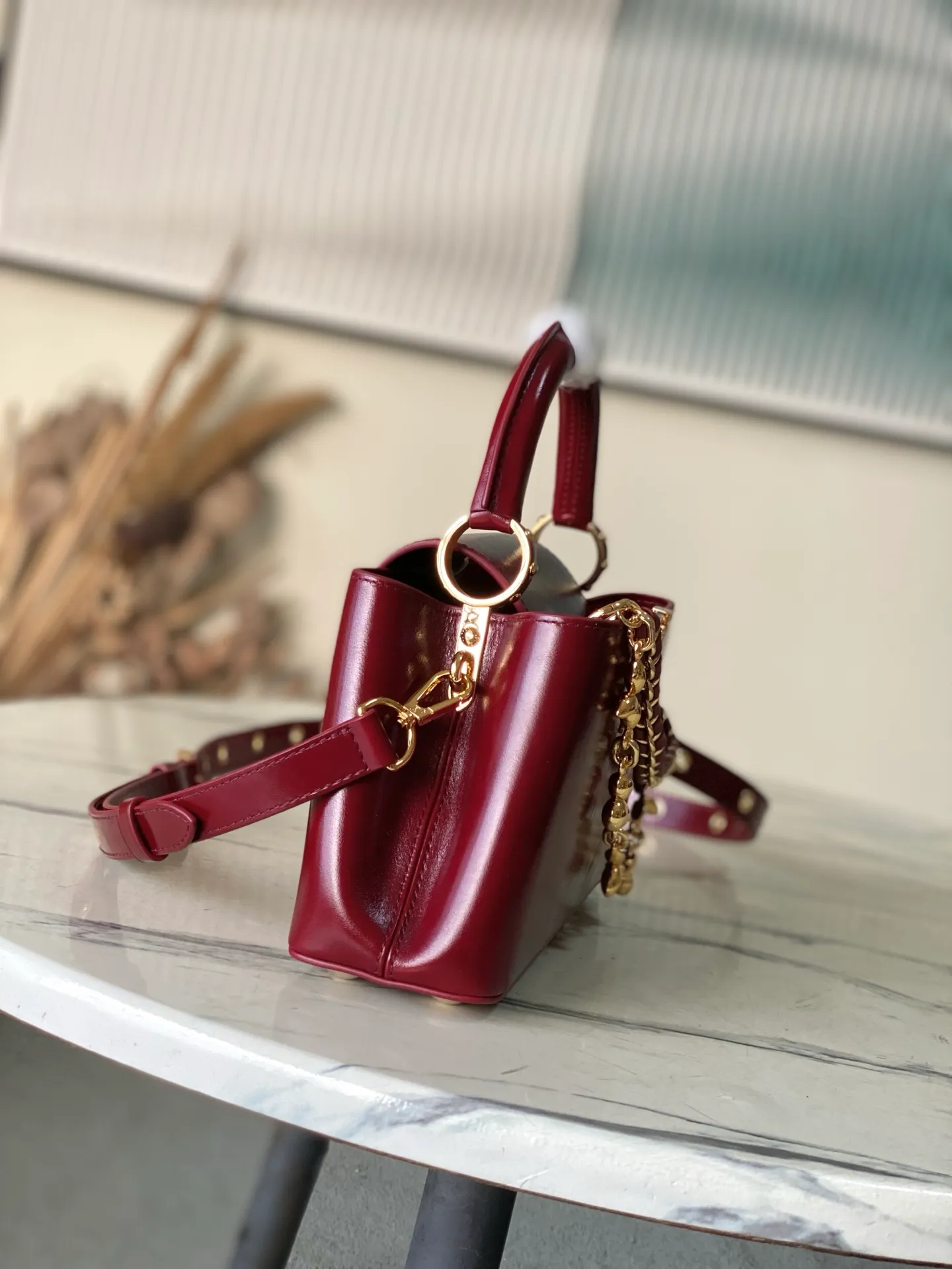 💰2360 "Special Grade Original Leather" M25473 Small Burgundy Oil Waxed Leather This Capucines East-WestBB handbag gives the leather a pleated texture and expresses the new season trend. The cow leather trim outlines smooth lines. The LV letters and detachable chain shine with metallic luster. The spacious interior meets different storage needs. Various carrying methods show functional ingenuity. Size: 26.5*14*8CM