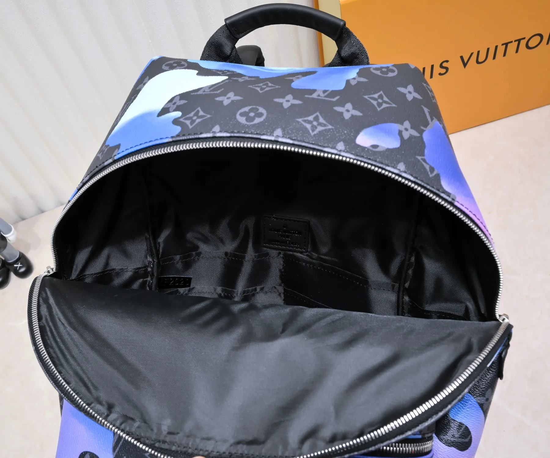 Batch 440💰M21429 This Discovery backpack is from the Room with a View capsule series, recalling designer Virgil Abloh's vision of floating clouds. The Monogram Eclipse canvas depicts a quiet sunrise in dreamy colors, and the cloud pattern spells out the freehand LV logo. 30.0 x 40.0 x 20.0 cm (L x H x W) • Sunrise Monogram Eclipse coated canvas • Cow leather trim • Textile lining • Metal hardware