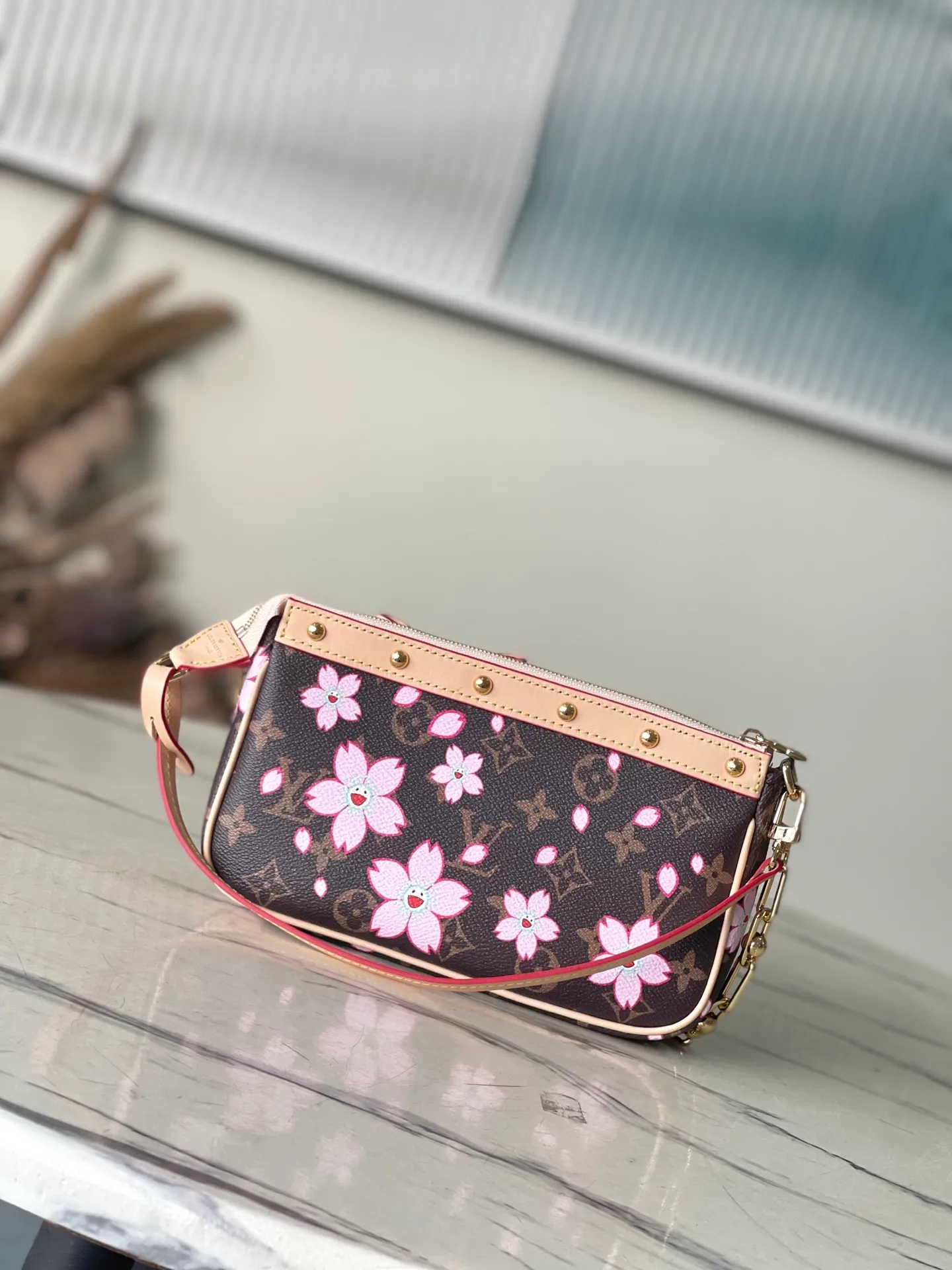 💰980 Top Original Order M13666 This Pochette Accessoires handbag is made of classic Monogram canvas with the bright Cherry Blossom pattern written by Takashi Murakami, which expresses the distinctive elements of the Louis Vuitton×Takashi Murakami replica series in a playful style. A leather bow and LV-engraved padlock accentuate the upper edge, while dazzling studs and a detachable chain add a touch of uninhibited style. Dimensions: 22 × 13 × 4 cm