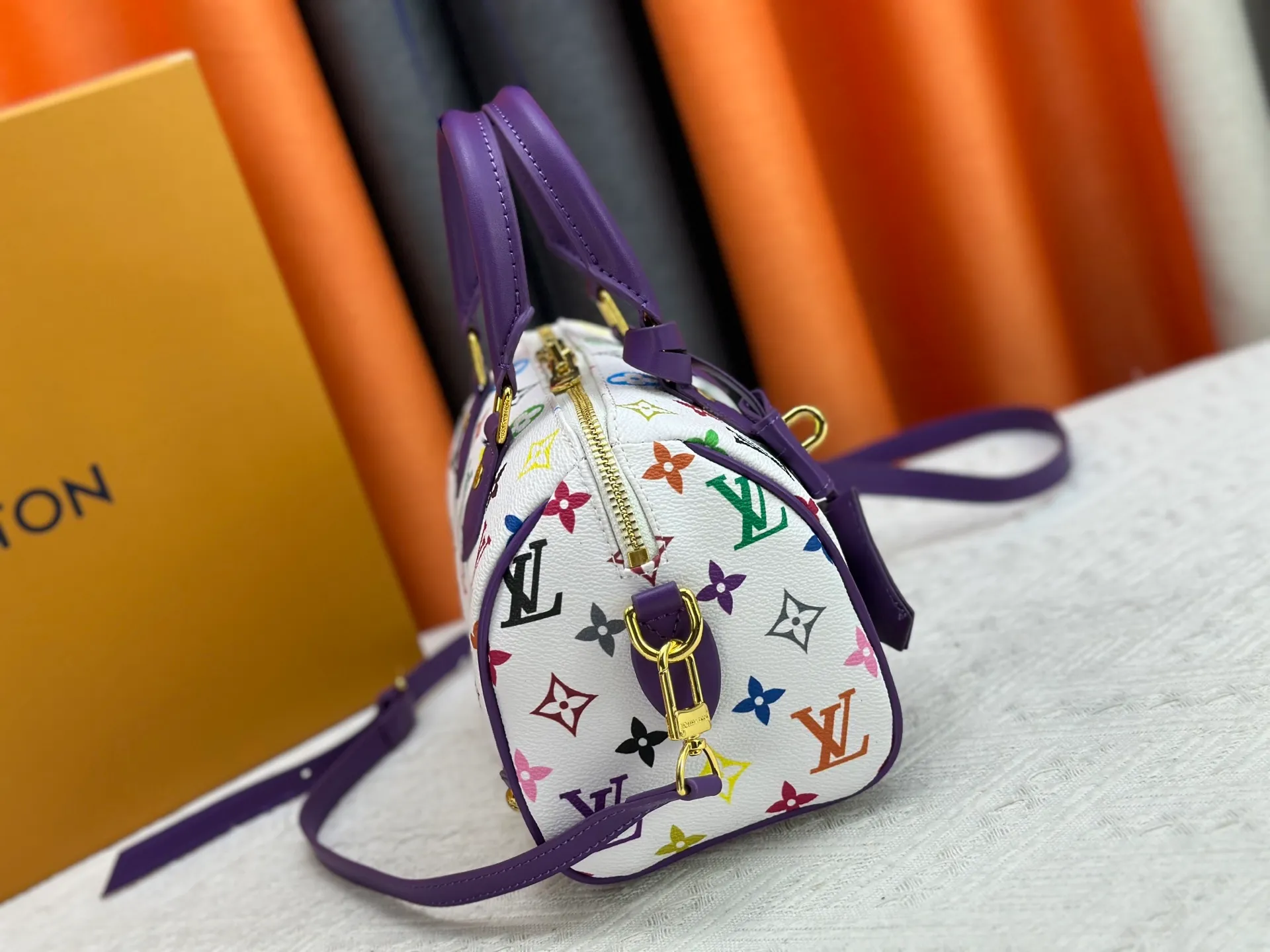 P260 upgraded original M58953 M46234 M46222 Speedy Bandoulière 20 handbag is made of soft coated canvas, and the full-length Monogram pattern is traced in colorful rainbow tones, highlighting the smart style of the Louis Vuitton x Murakami reissue series. The Toron handle and detachable shoulder strap are constructed of cow leather, the metal corners recall classic luggage elements, and the bow-shaped key bag and padlock add brand touches. Dimensions: 20.5 x 13.5 x 12.0 cm (length x height x width)